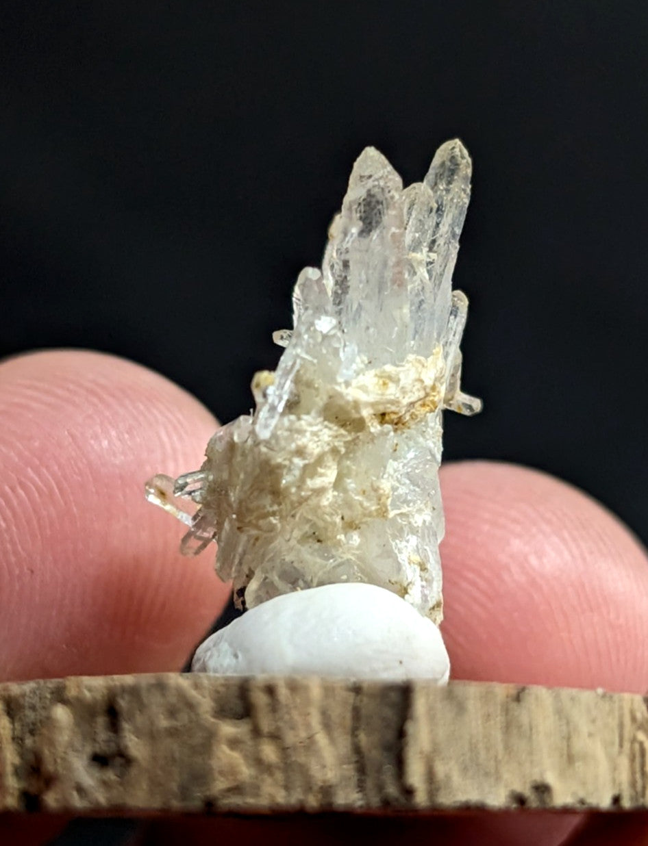 A translucent, clear quartz crystal cluster with sharp, pointed facets and a slightly cloudy base.