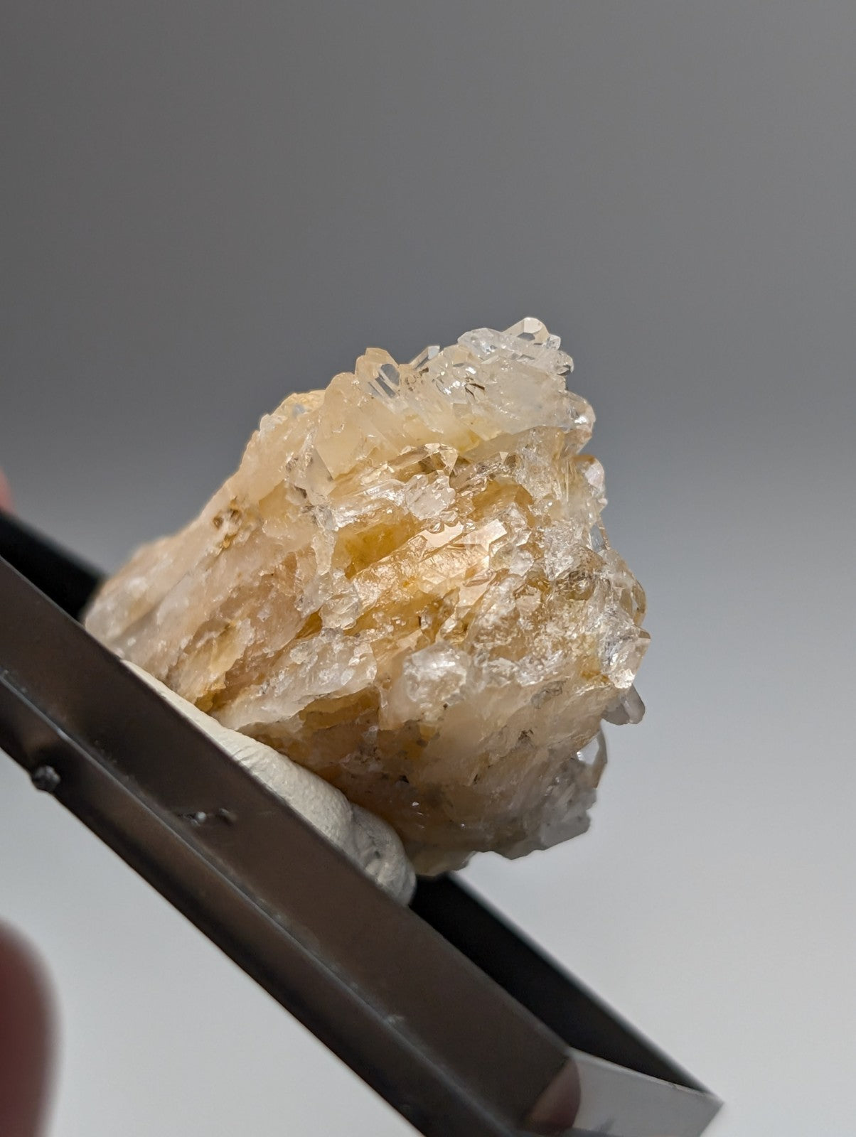 Solution quartz crystal cluster with translucent pale yellowish facets mounted in a photo case from saline county arkansas