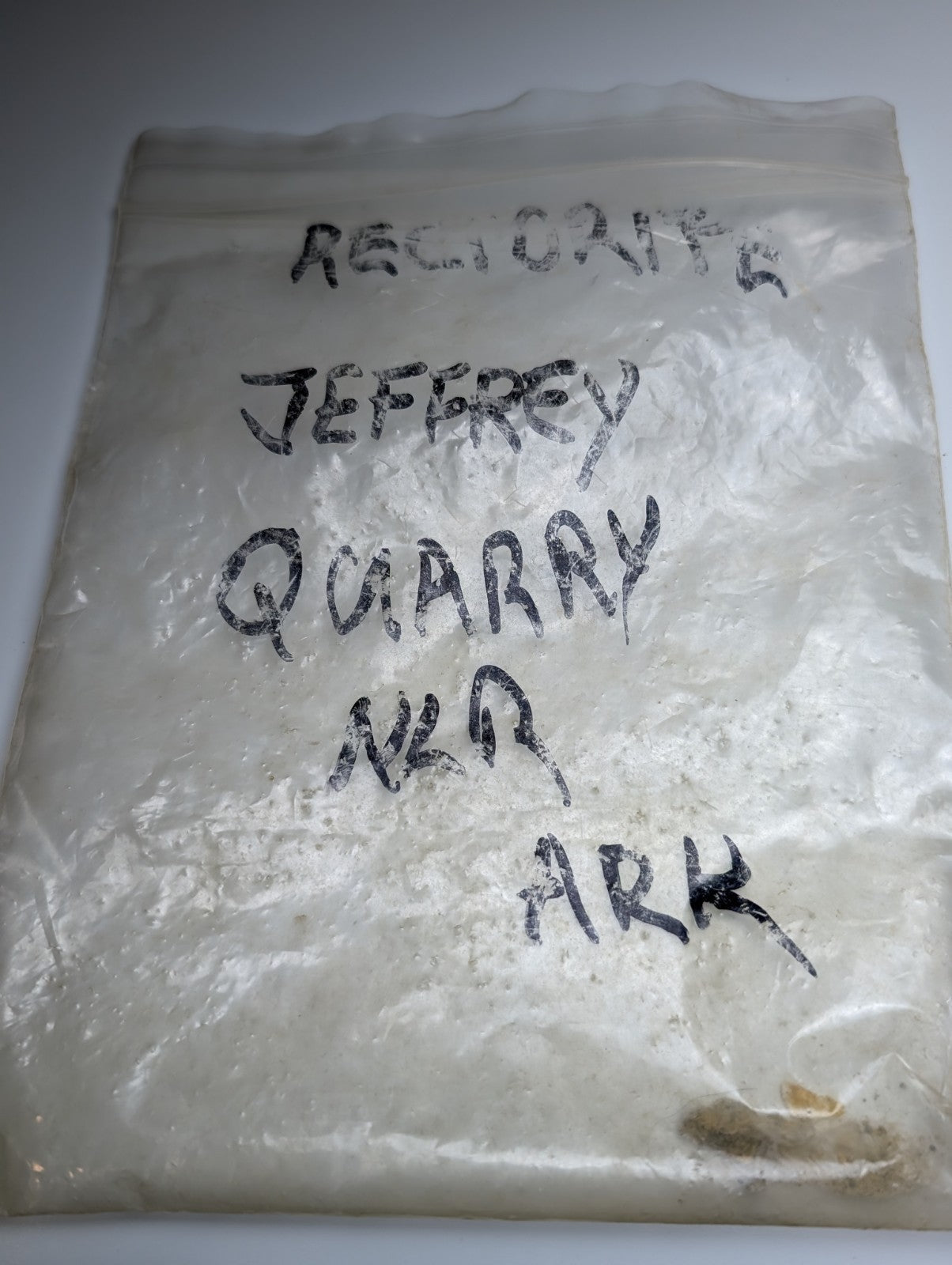 A clear plastic bag of white powder labeled solution quartz in rectorite from Jeffrey Quarry Arkansas ex Delinde