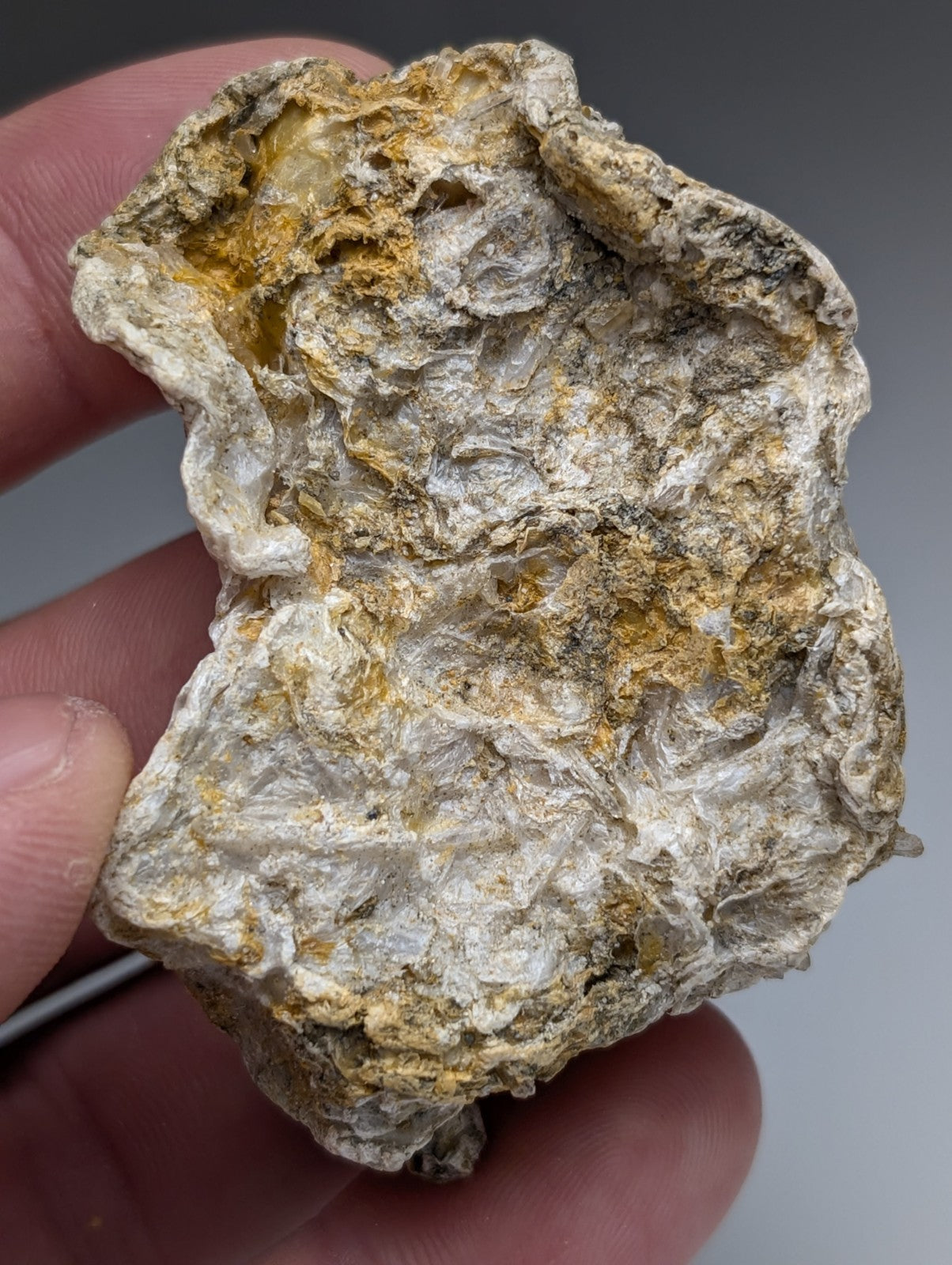 A weathered solution quartz in rectorite with white and yellow mineral patches from Jeffrey Quarry Arkansas