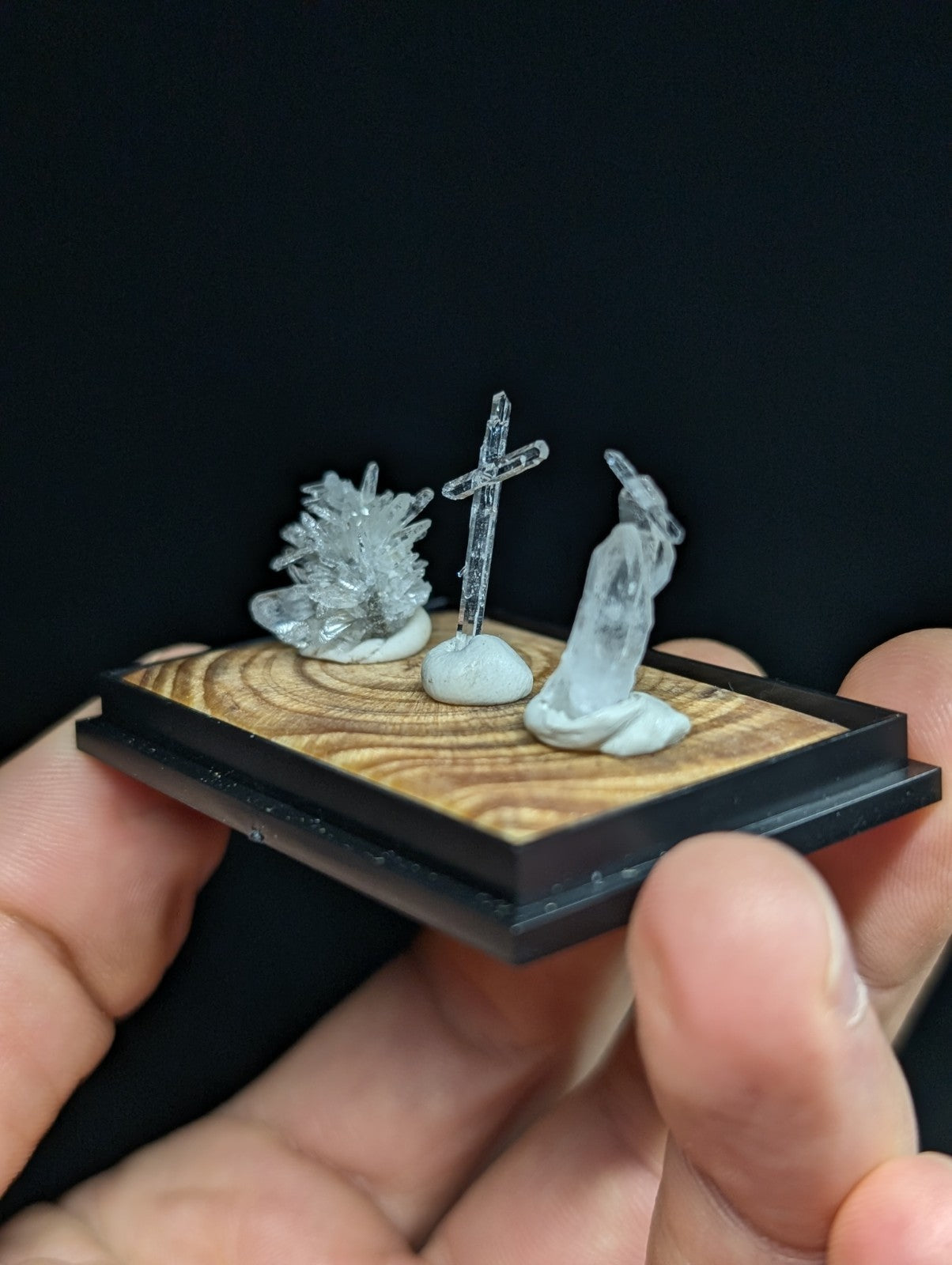 透明水晶材质的微型宗教场景摆件，包含十字架、跪地人物和晶体簇。