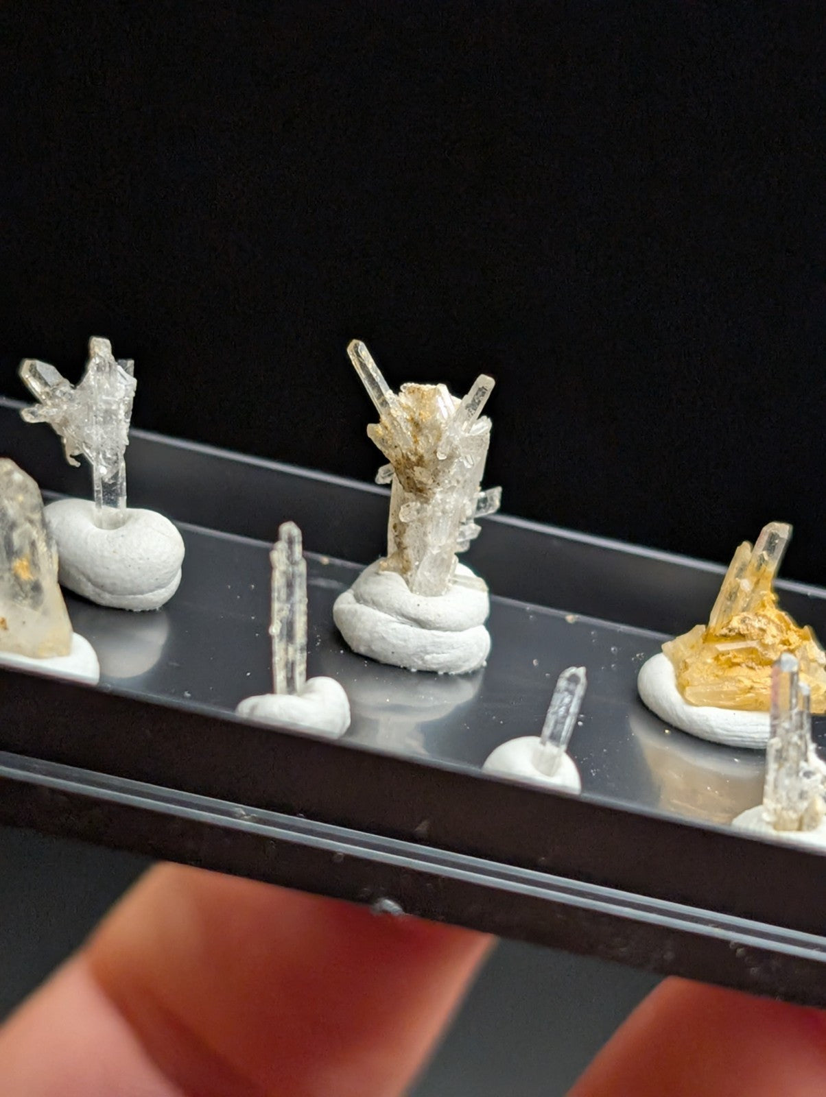 Clear quartz crystal specimens mounted on white ceramic bases.