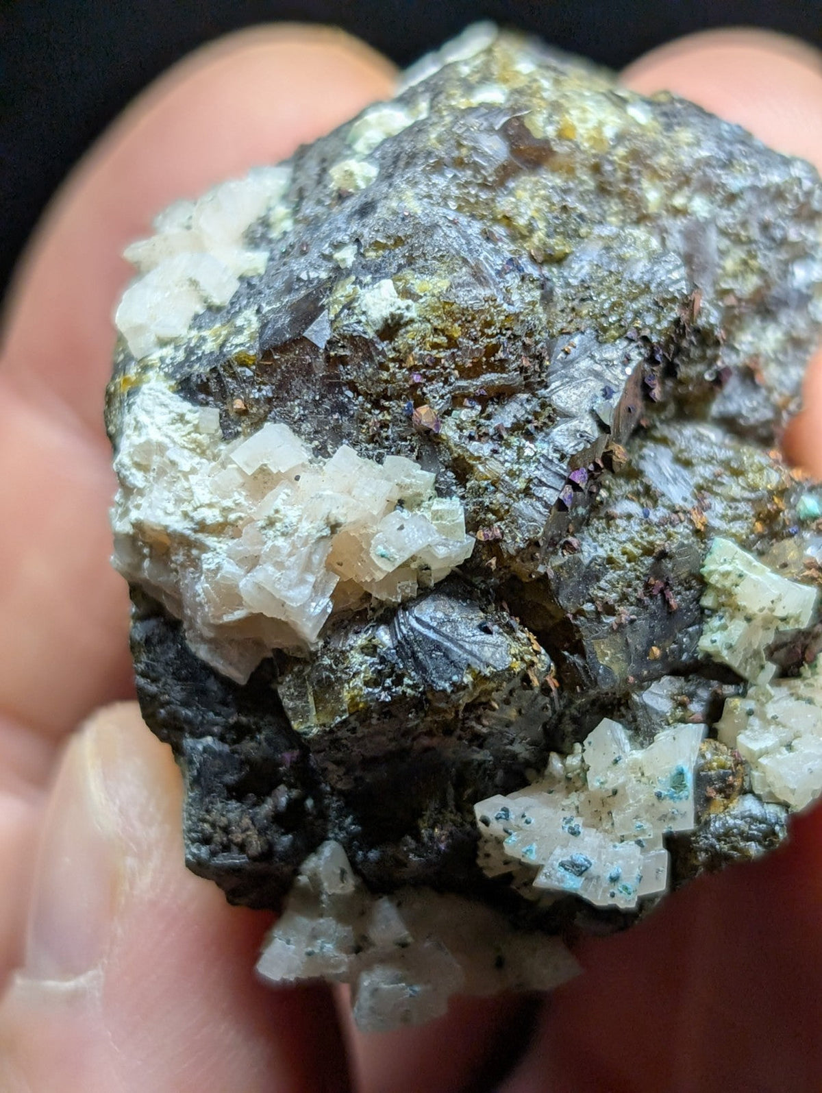 A rugged, irregularly shaped mineral specimen featuring a mix of dark gray and black matrix with prominent translucent white crystalline formations.