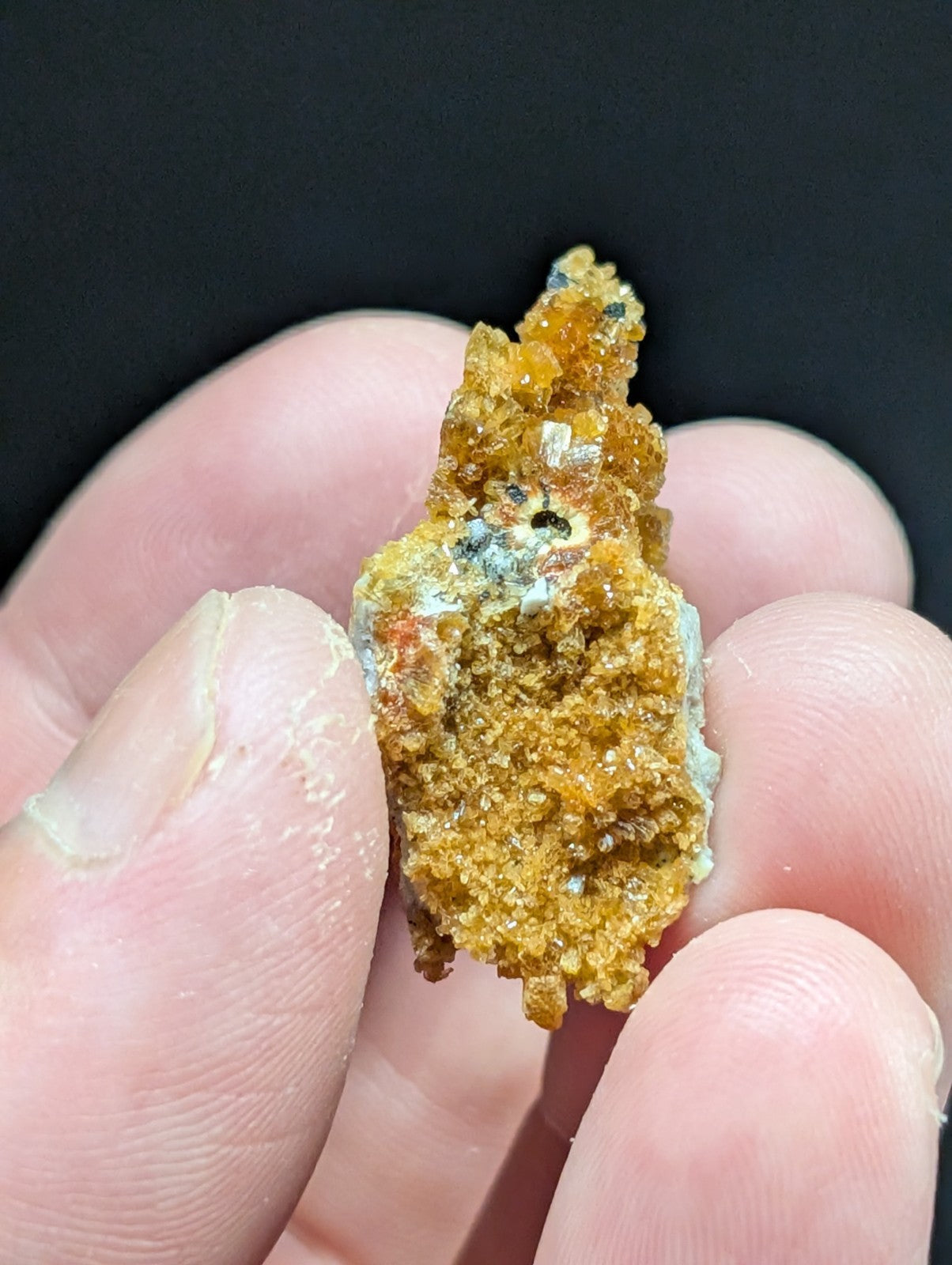 A textured, orange-yellow mineral specimen with crystalline formations and patches of greenish-blue patina.