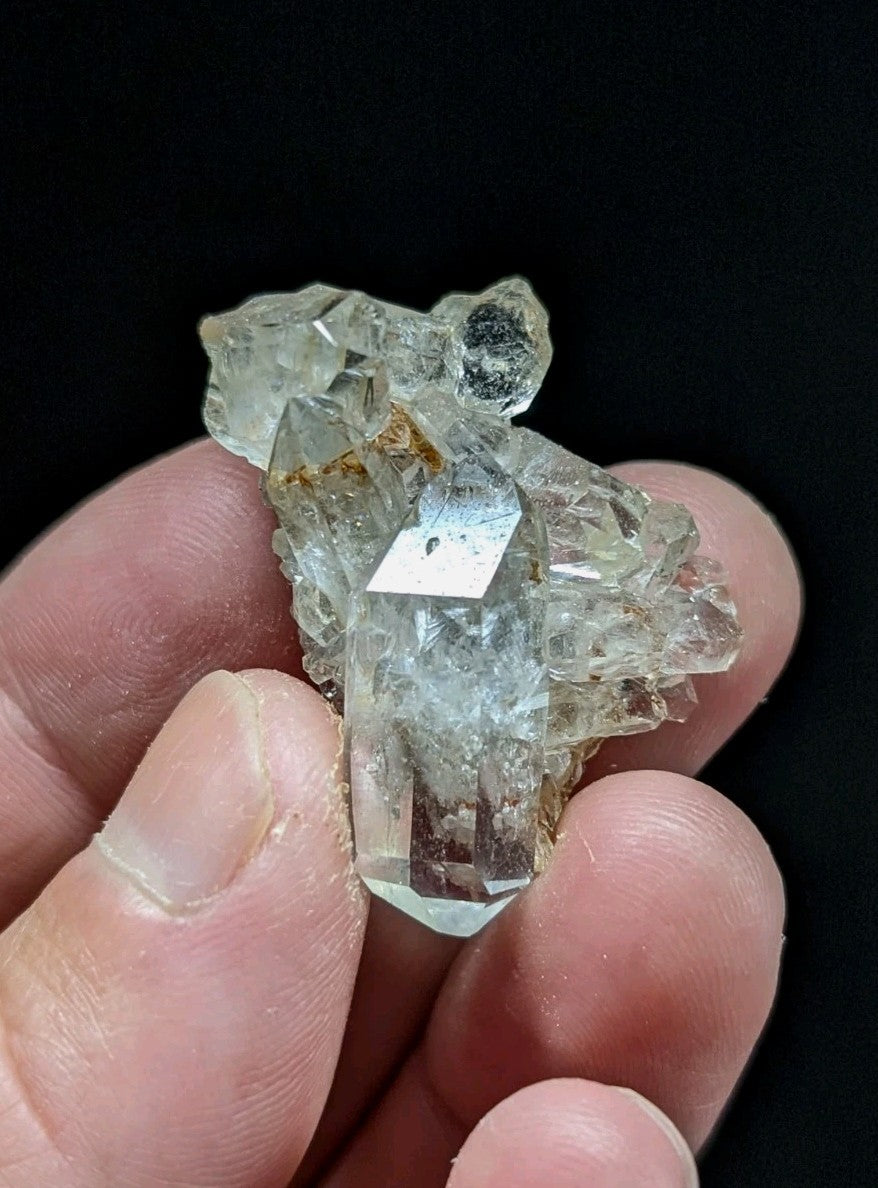 A translucent, clear quartz crystal cluster with a rough, jagged surface and subtle internal inclusions.