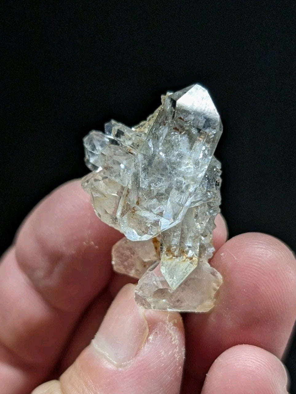 A translucent, clear quartz crystal cluster with sharp facets and a slightly cloudy appearance.