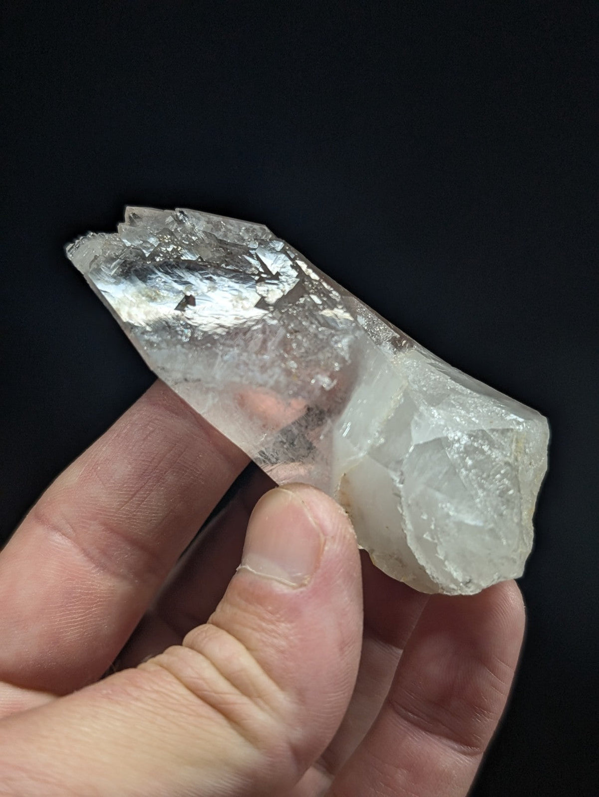 A translucent, clear quartz crystal with a rough, jagged surface and natural inclusions.