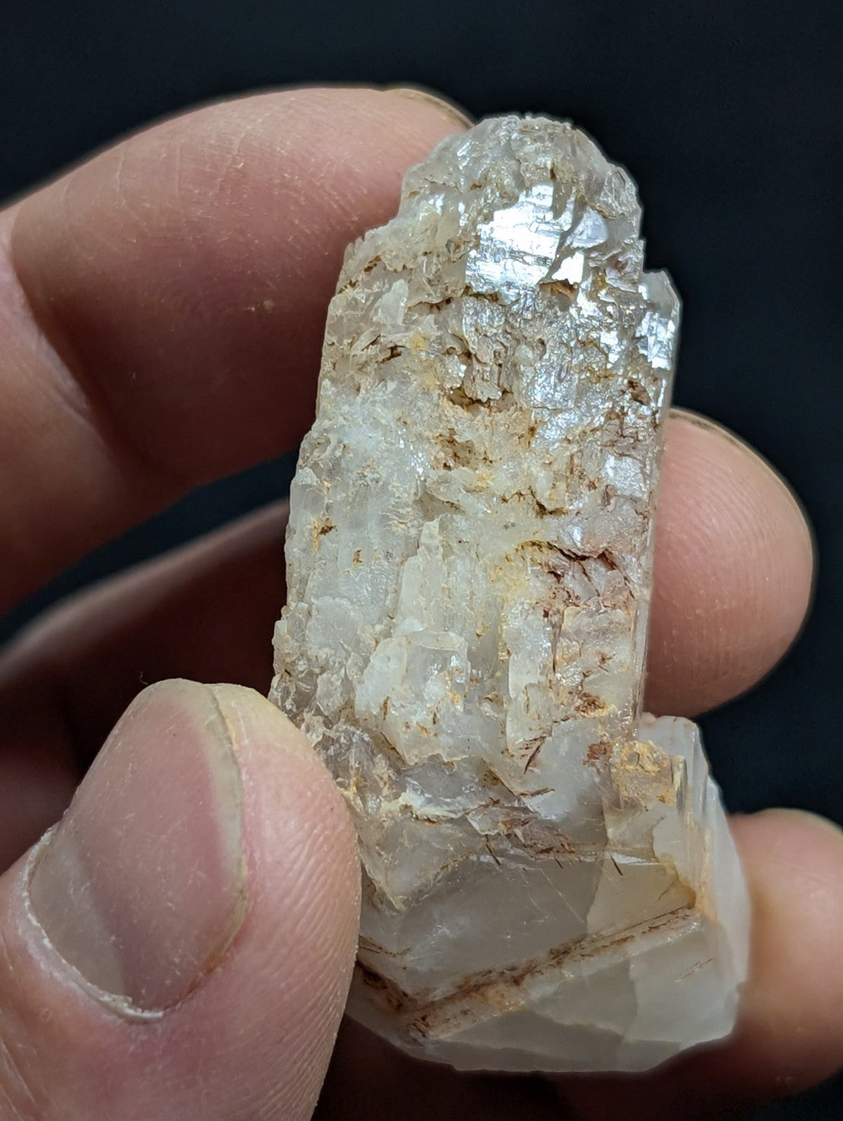 A translucent, crystalline quartz specimen with a rough, jagged surface and subtle golden inclusions.