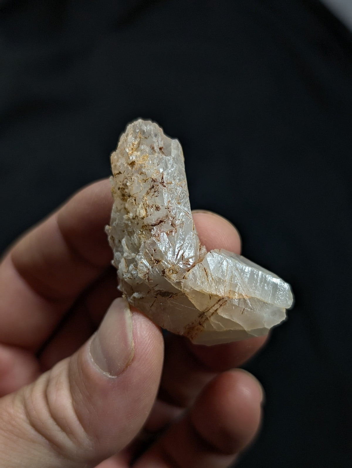 A translucent, pale quartz crystal cluster with golden inclusions and a rough, jagged surface.