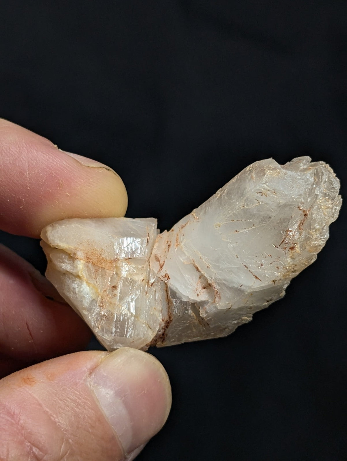 A translucent, pale quartz crystal with natural facets and subtle brownish inclusions.
