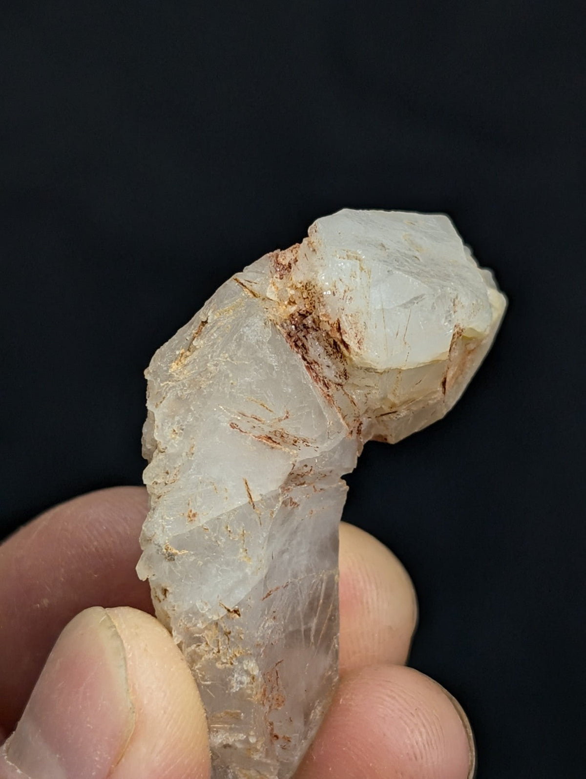 A translucent, pale quartz crystal with subtle brown inclusions and a natural, jagged form.