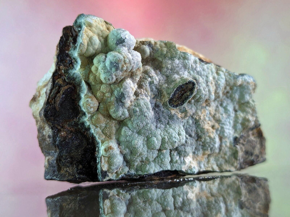 A striking green and black mineral specimen with a textured, bumpy surface.