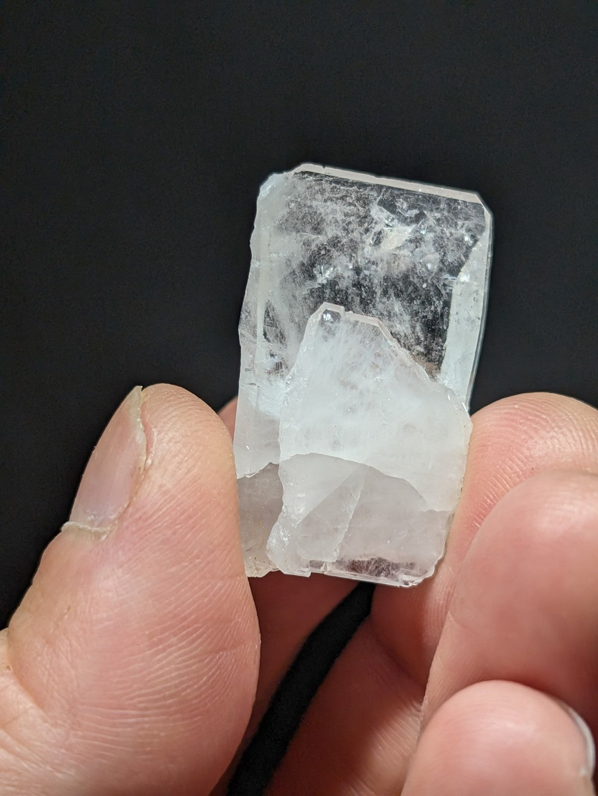 A translucent, irregularly shaped crystal with a clear and slightly cloudy appearance.