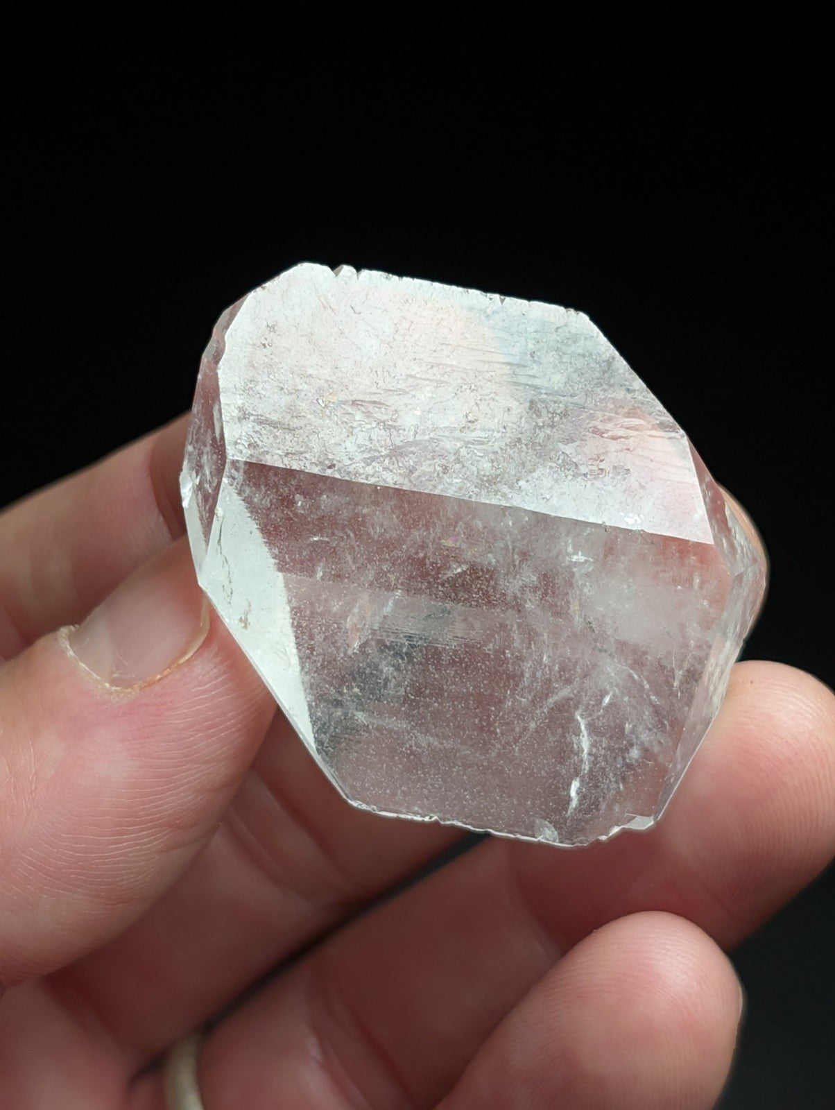 A translucent, faceted quartz crystal with a pale blue tint and visible internal inclusions.