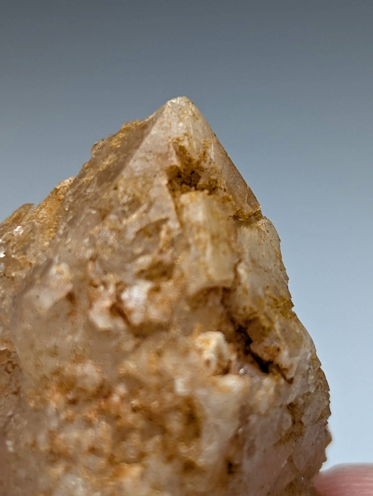 Unique dissolution quartz crystal point with translucent golden hue and rough textured surface from garland county arkansas