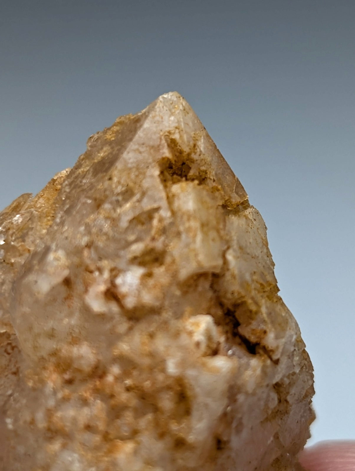 Unique dissolution quartz crystal point with translucent golden hue and rough textured surface from garland county arkansas
