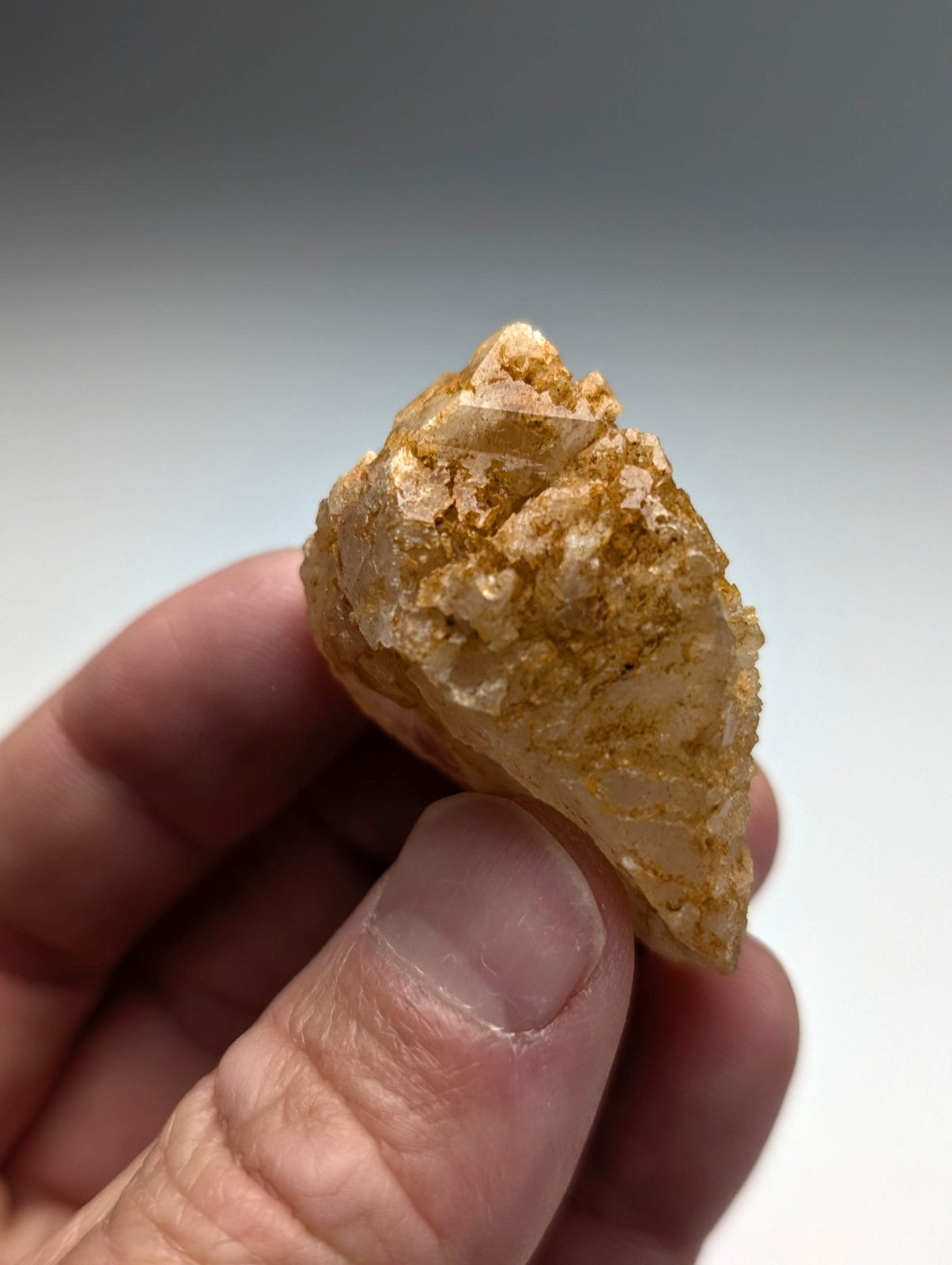 Unique dissolution quartz crystal point in translucent golden yellow with crystalline facets and earthy matrix from Arkansas