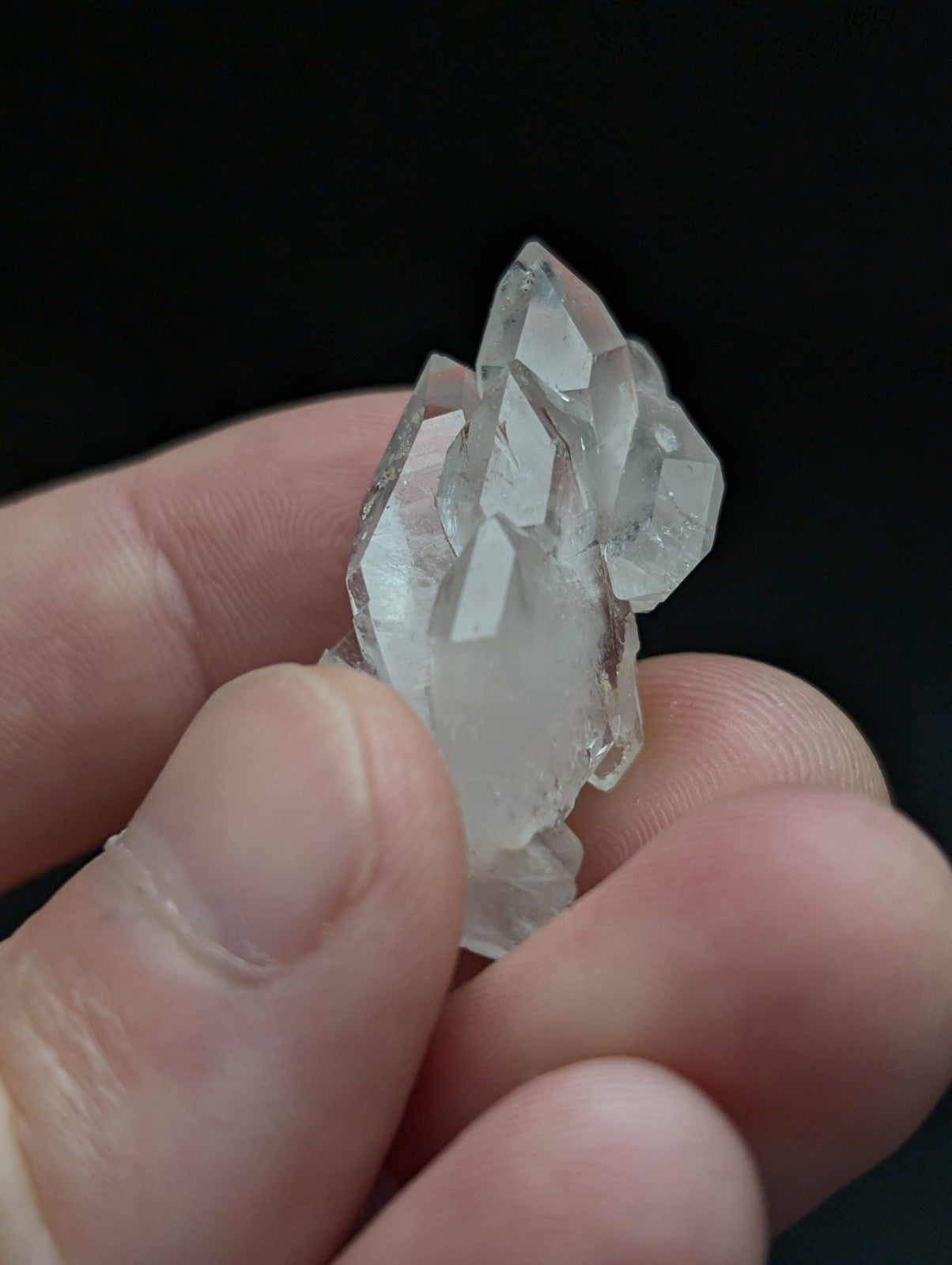 A clear double terminated floater quartz crystal cluster held in hand from montgomery county arkansas