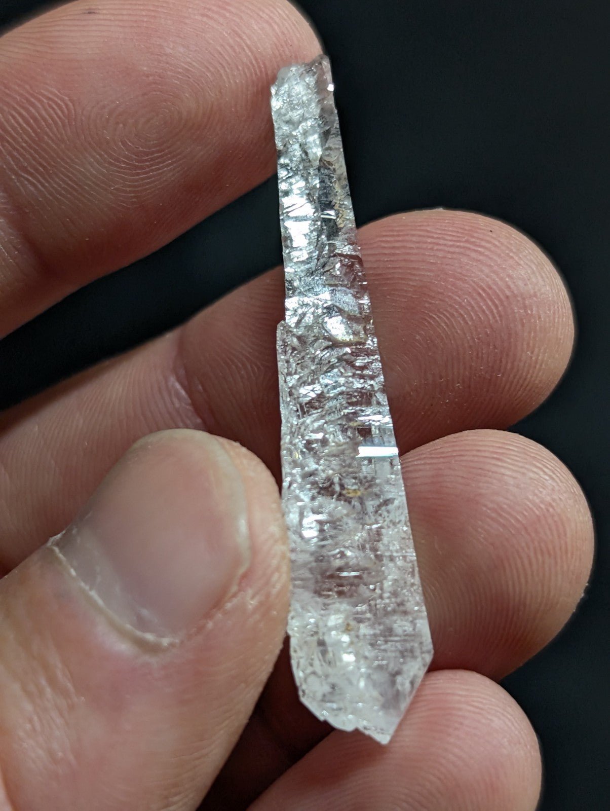 A clear, translucent quartz crystal with a rough, faceted surface and natural internal inclusions.
