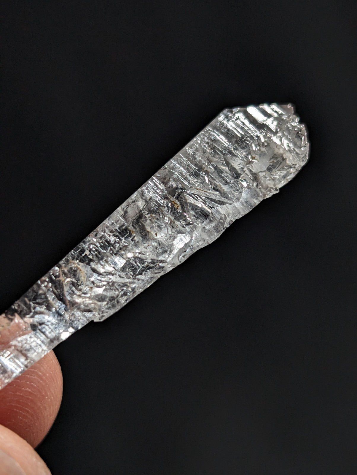 A clear, faceted raw diamond with a natural crystalline structure and visible internal inclusions.