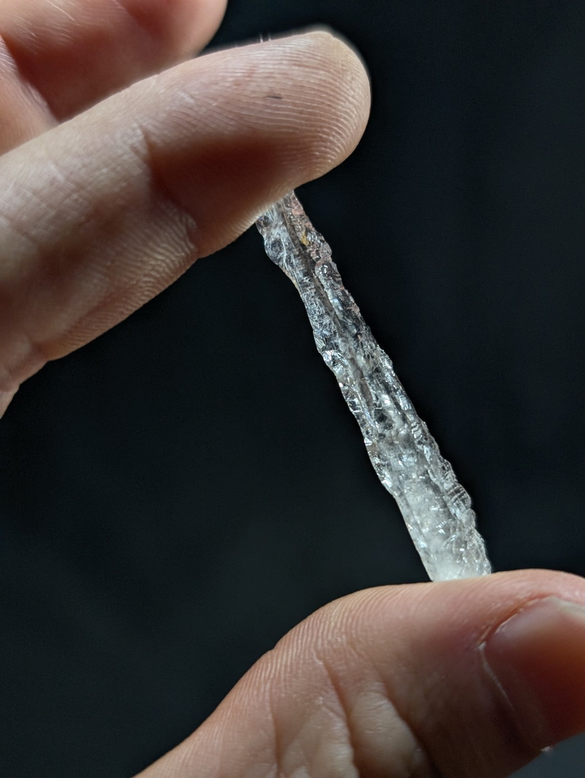 A translucent, crystalline ice shard with jagged edges and a slightly rough texture.