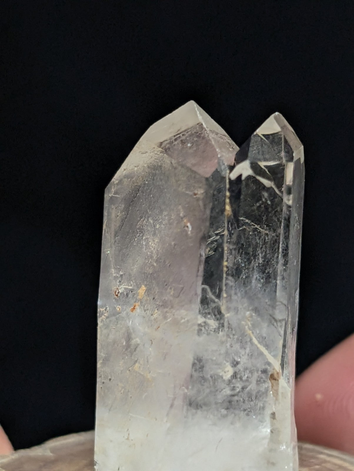 A clear, translucent quartz crystal with two distinct prismatic points and subtle internal inclusions.