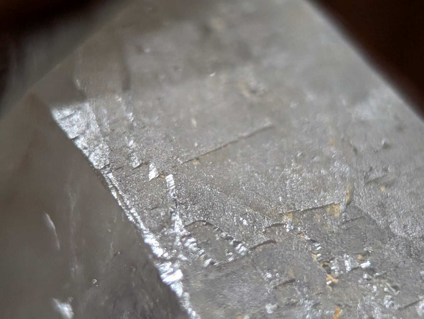 A translucent, grayish quartz crystal with natural facets and subtle internal striations.