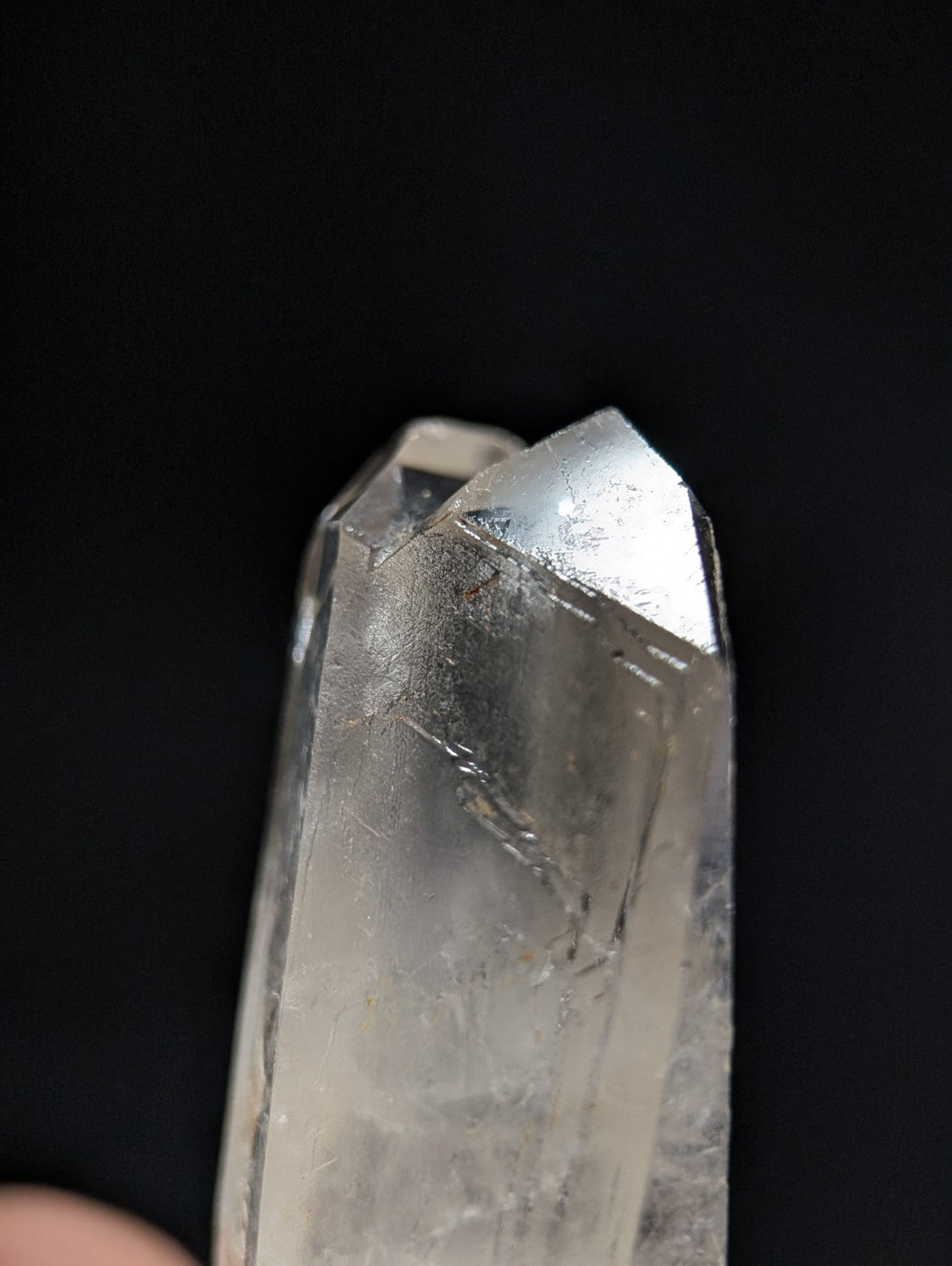A clear, translucent quartz crystal with a pointed tip and visible internal inclusions.