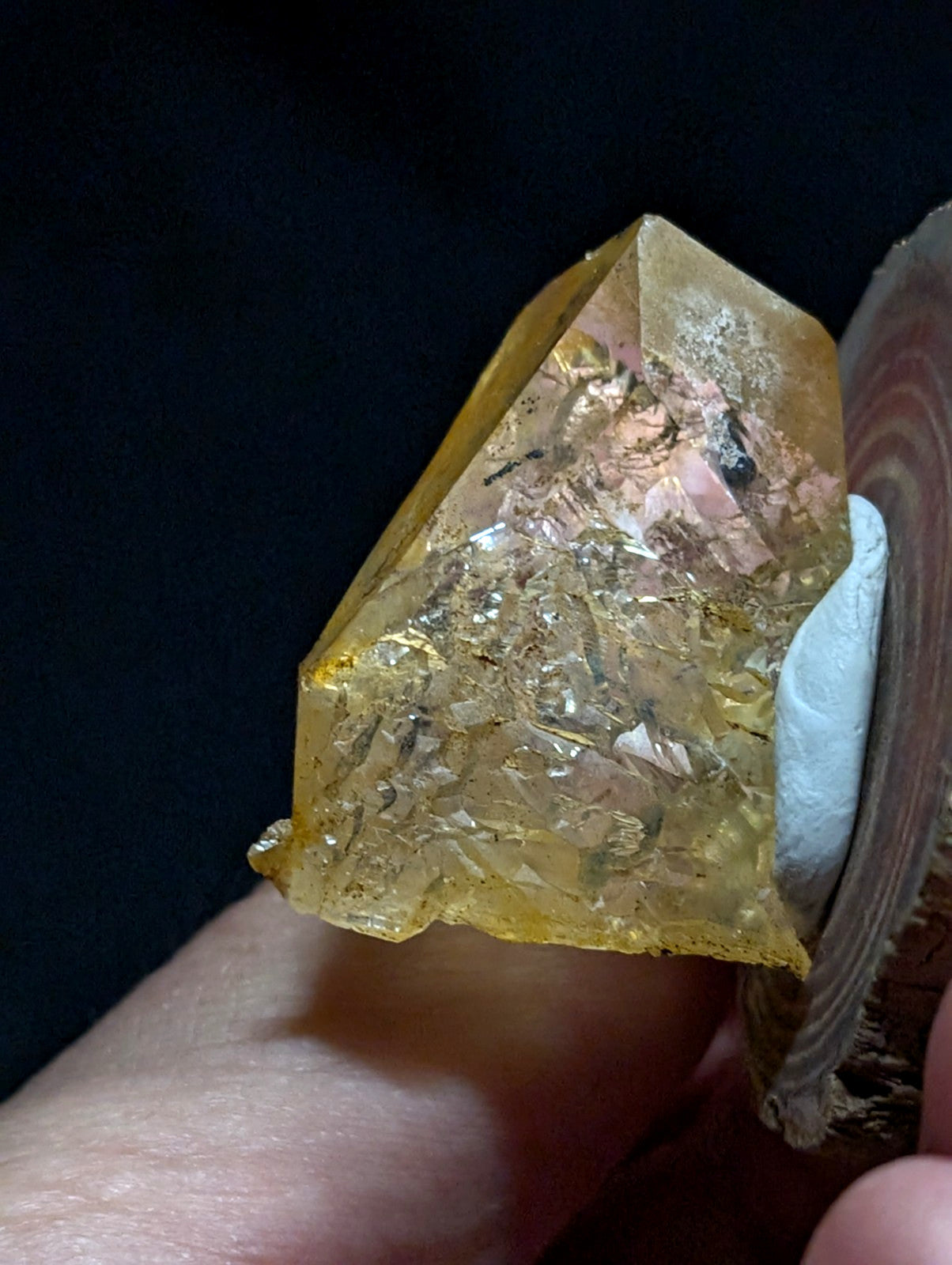 A translucent golden-yellow crystal with a faceted, geometric shape and internal metallic inclusions.