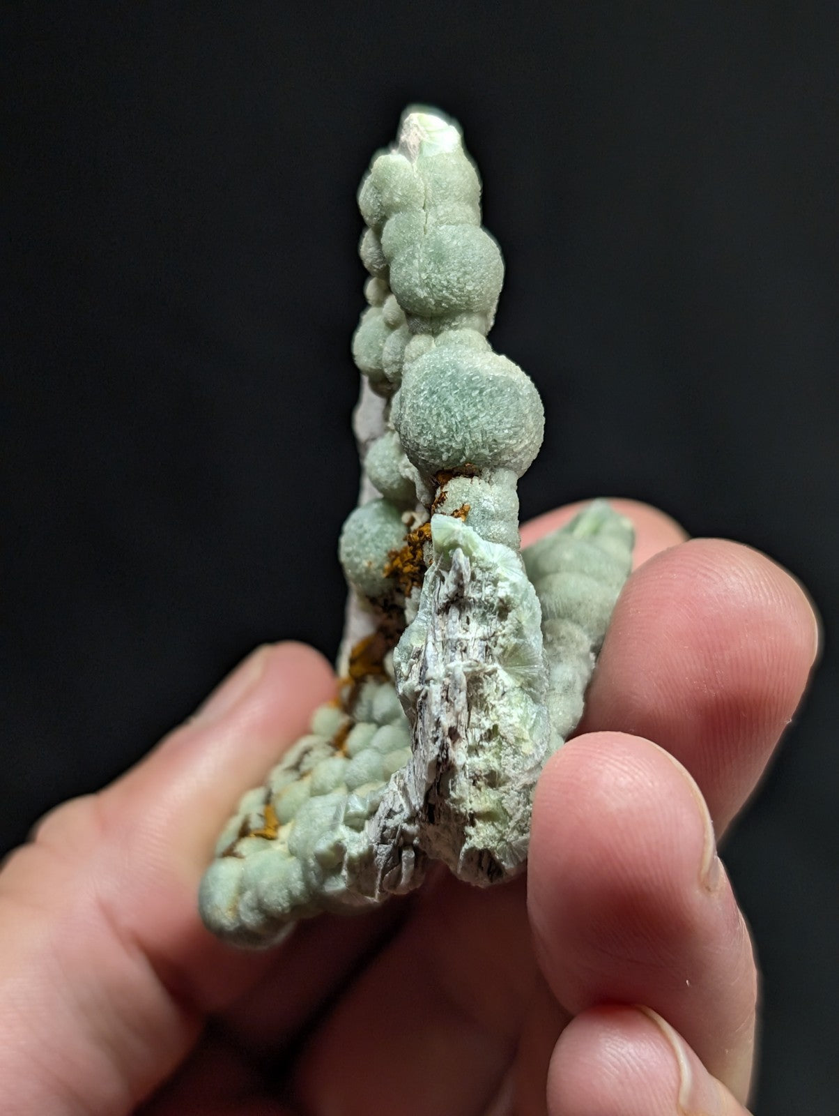 A pale green, textured mineral specimen with rounded nodules and a rough surface.