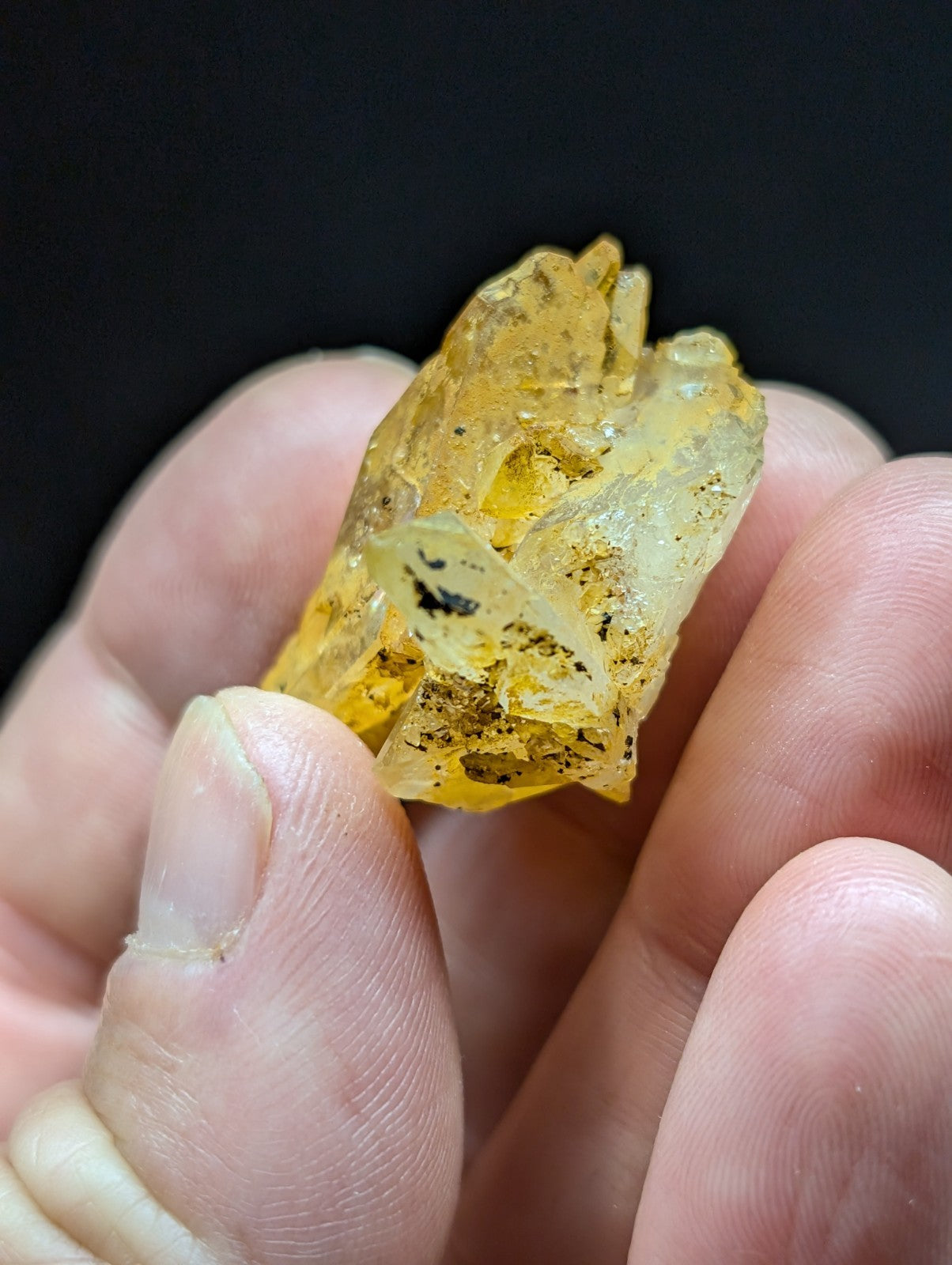 A translucent yellowish amber specimen with visible internal inclusions and a rough, irregular crystalline surface.