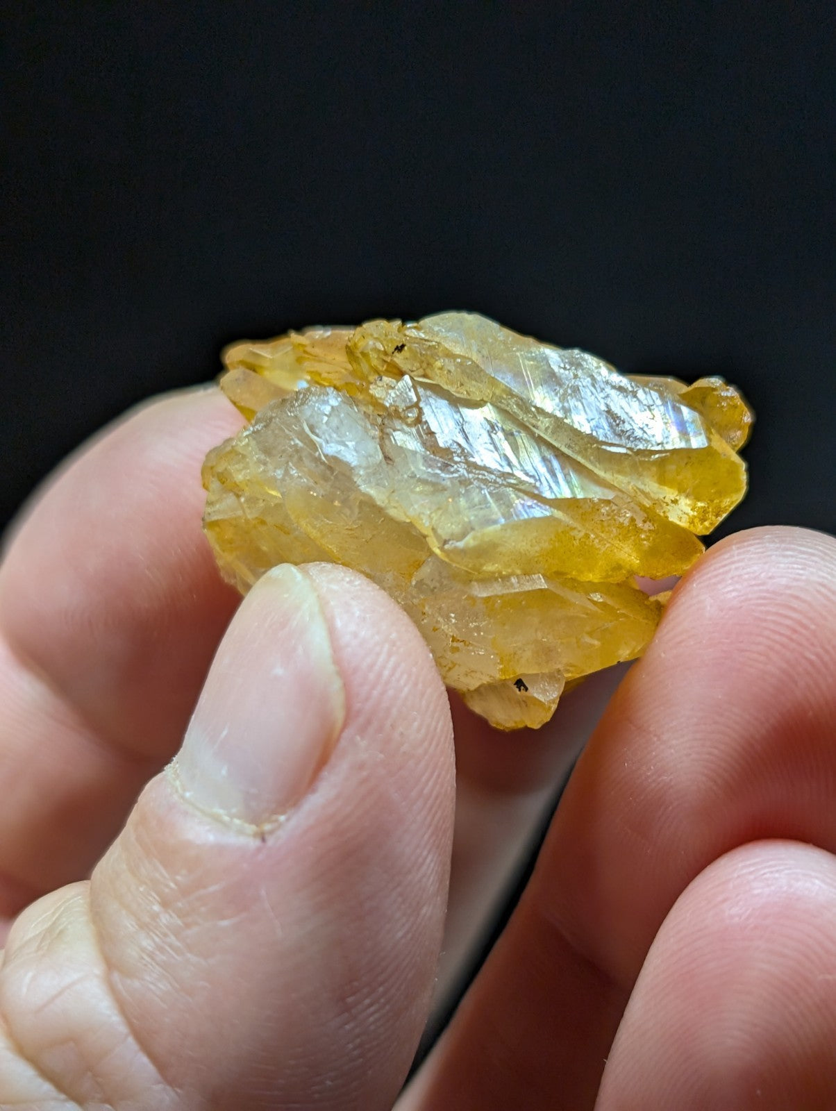 A translucent yellow crystal with layered, jagged facets and a glossy surface.