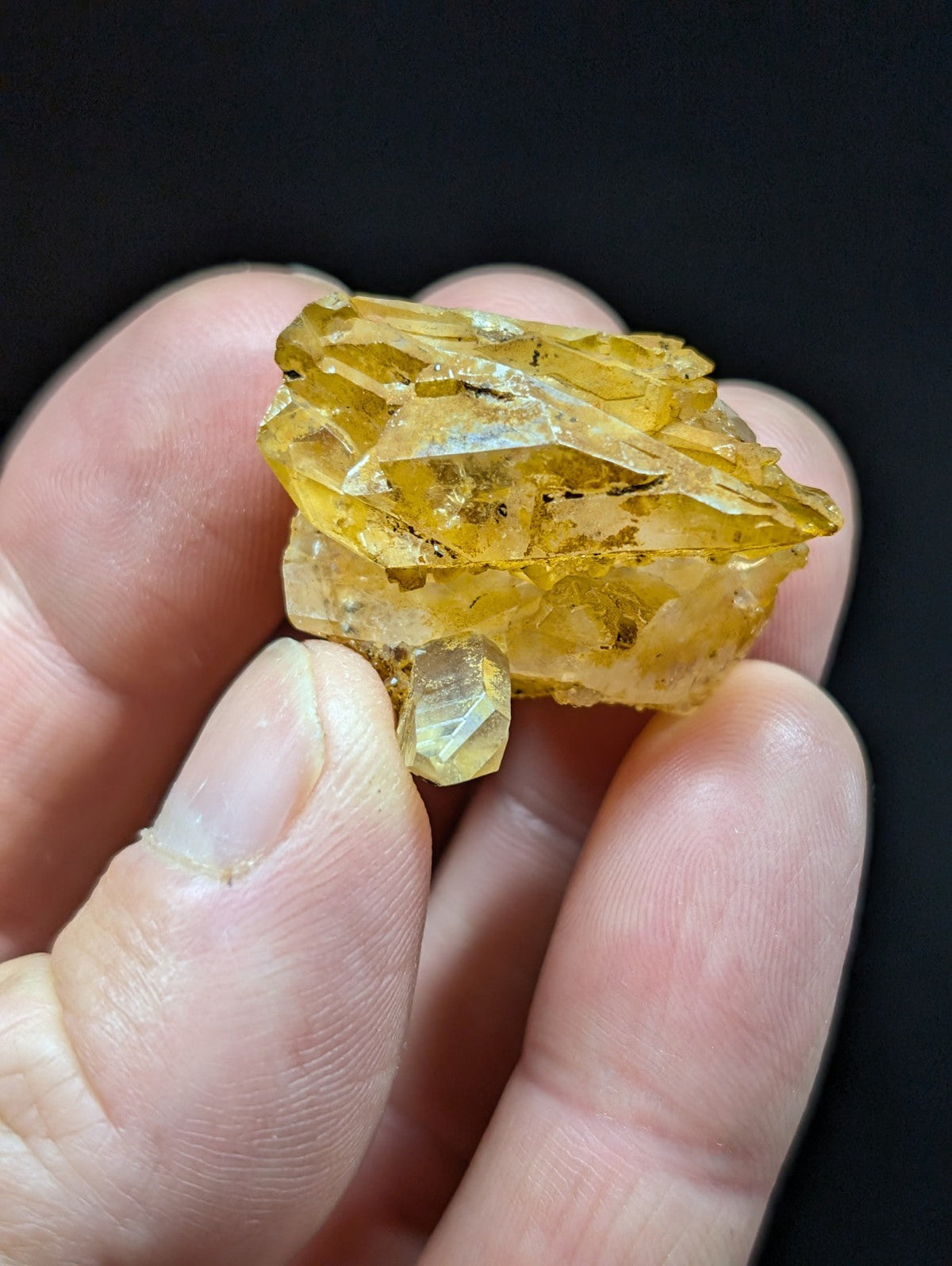 A translucent yellow crystal cluster with sharp, angular facets and a slightly cloudy appearance.
