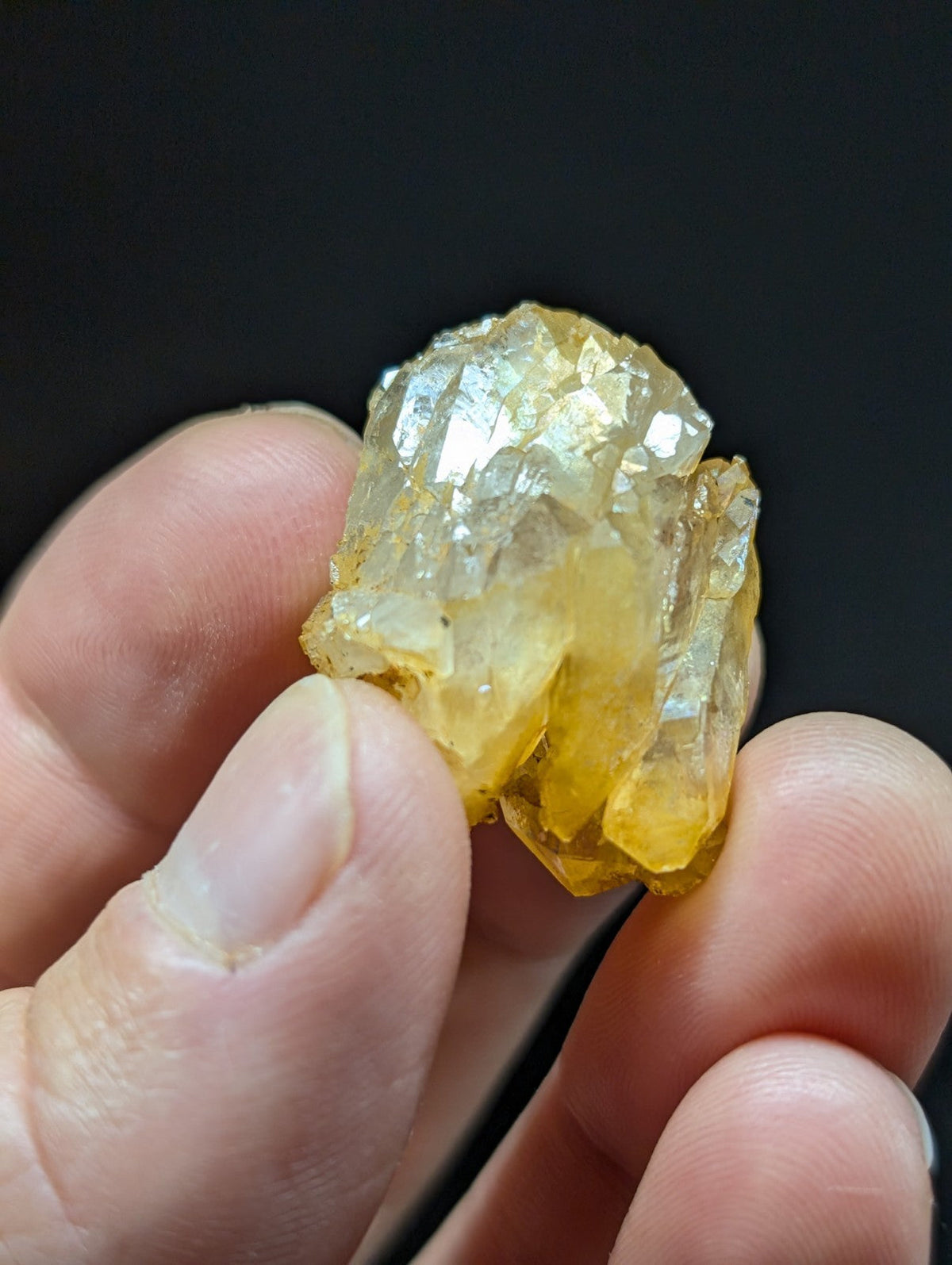 A cluster of translucent yellow crystals with sharp, faceted edges and a slightly cloudy appearance.