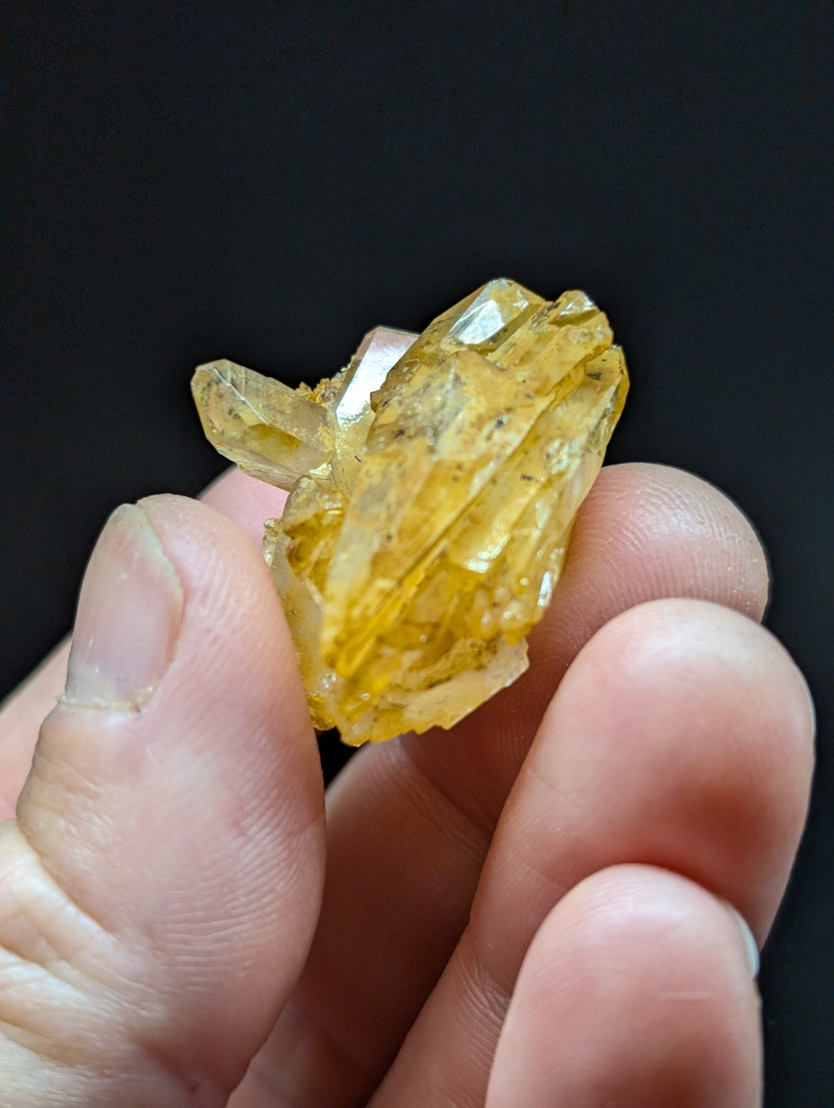 A translucent yellow crystal cluster with sharp, angular facets and a slightly cloudy appearance.