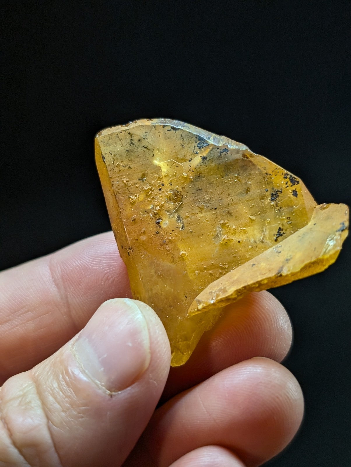 A translucent amber-colored resin fragment with a rough, irregular shape and visible internal inclusions.