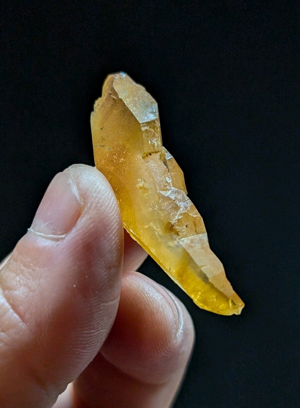 A translucent golden-yellow crystal with jagged edges and a natural, raw appearance.
