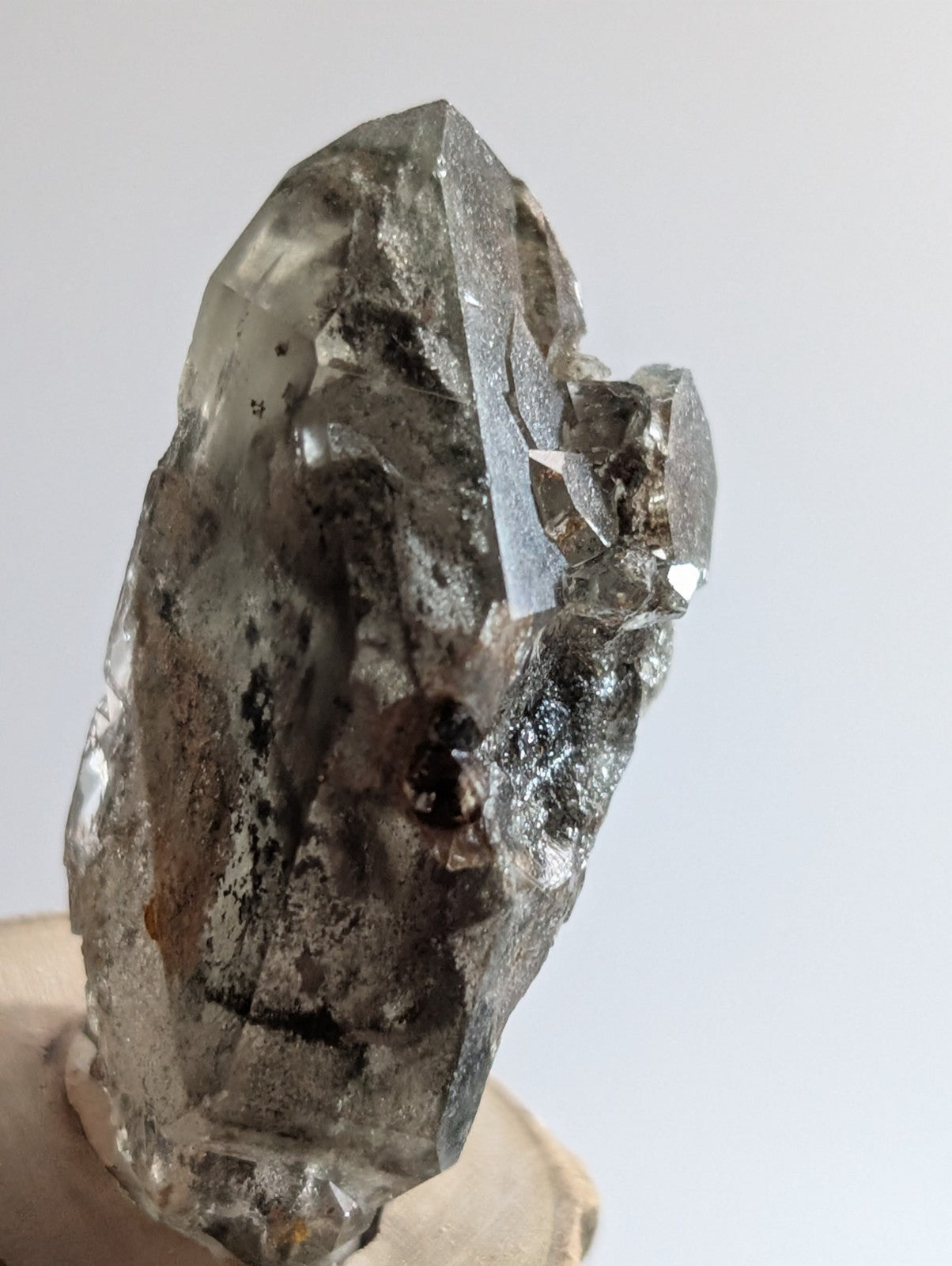A translucent gray quartz crystal with a rough, jagged surface and visible internal inclusions.