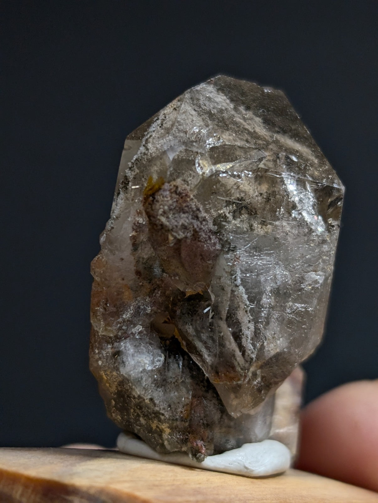 A translucent smoky quartz crystal with natural inclusions and a faceted, irregular shape.