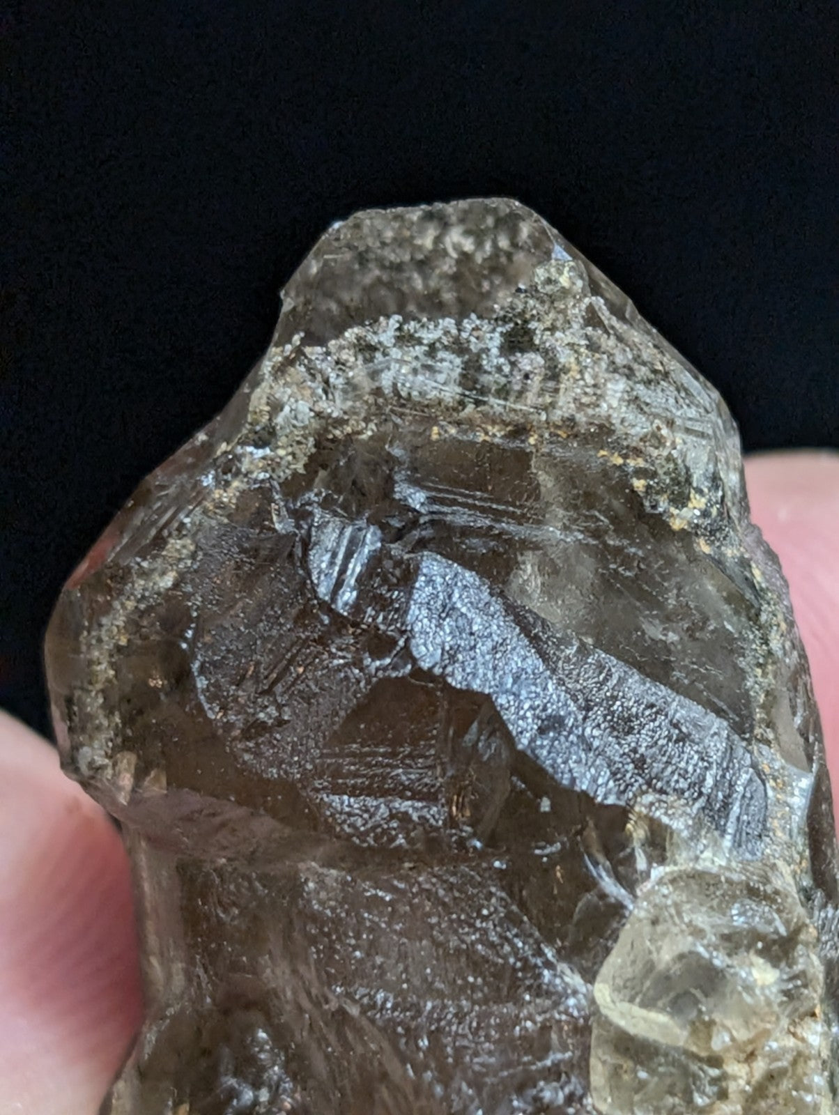 A rough, translucent brown crystal with visible internal striations and a slightly cloudy texture.