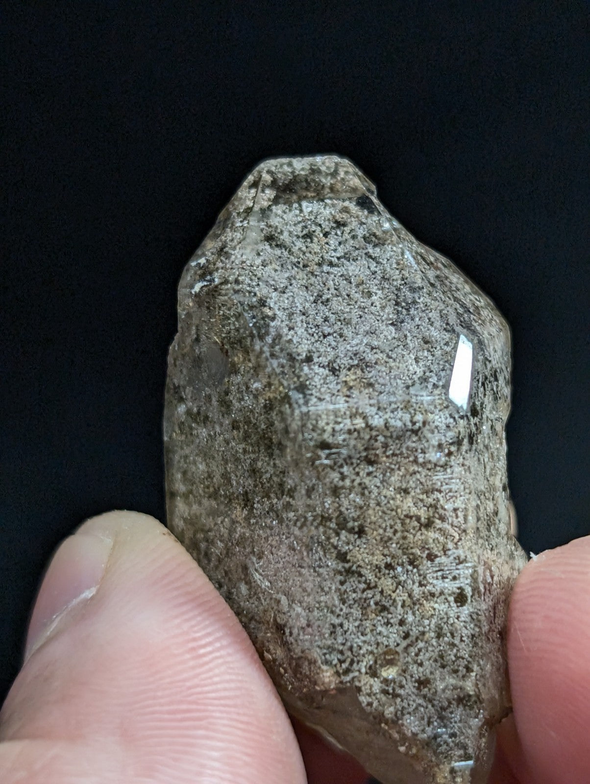A rough, translucent gray quartz crystal with a natural, faceted surface and subtle internal inclusions.