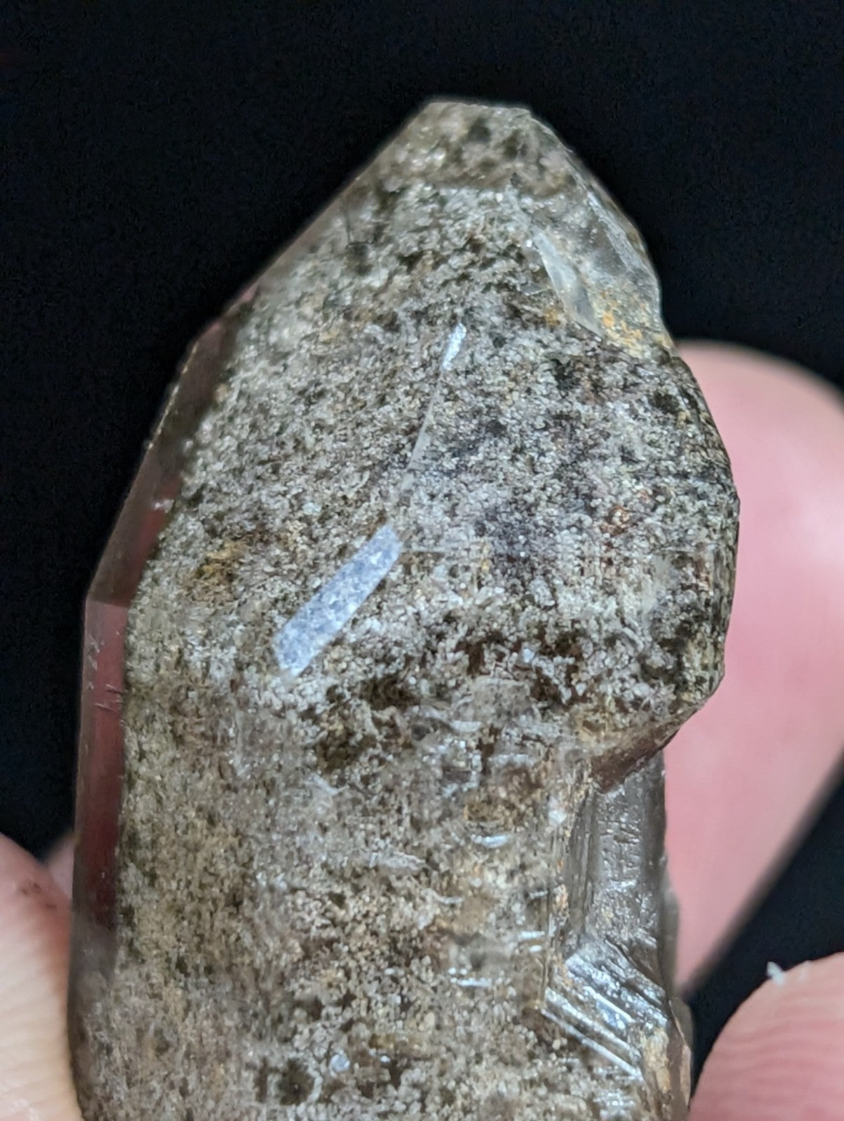 A translucent, smoky quartz crystal with a rough, natural surface and visible internal inclusions.