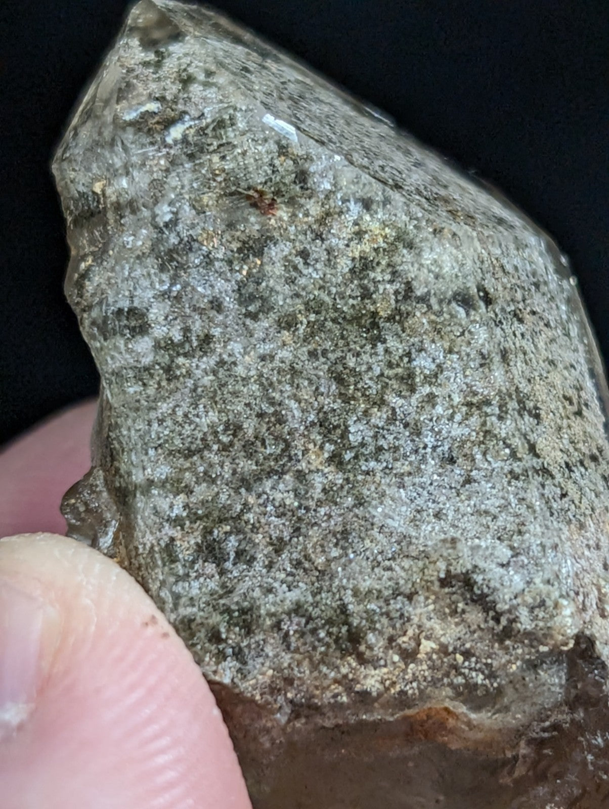 A rough, translucent gray rock with speckled patterns and a slightly glossy surface.