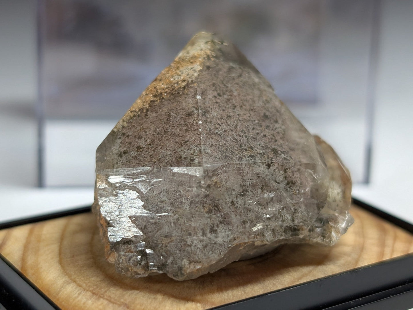 A translucent, grayish quartz crystal with a rough, natural surface and subtle internal striations.