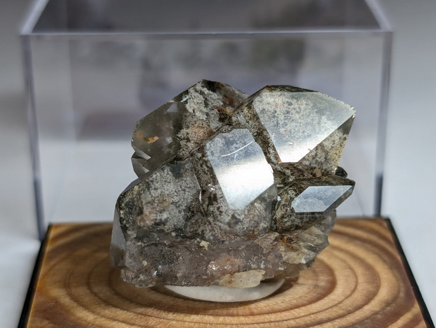 A translucent gray quartz crystal cluster with sharp, faceted surfaces and a rougher matrix base.