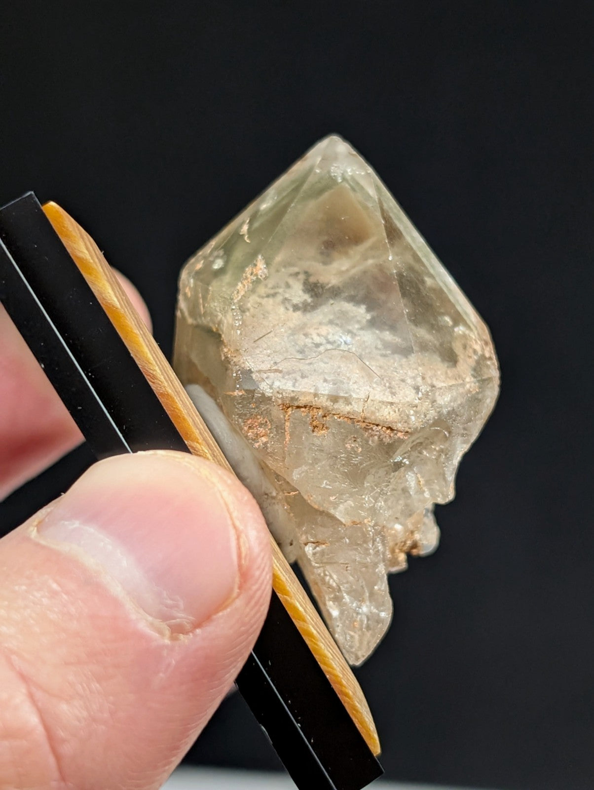 A translucent, pale yellowish quartz crystal with visible internal inclusions and a rough, faceted surface.
