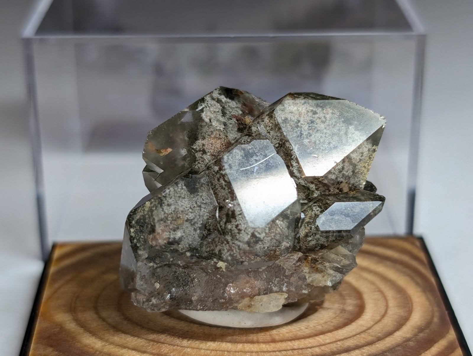 A translucent gray quartz crystal cluster with sharp, faceted surfaces and a rougher matrix base.
