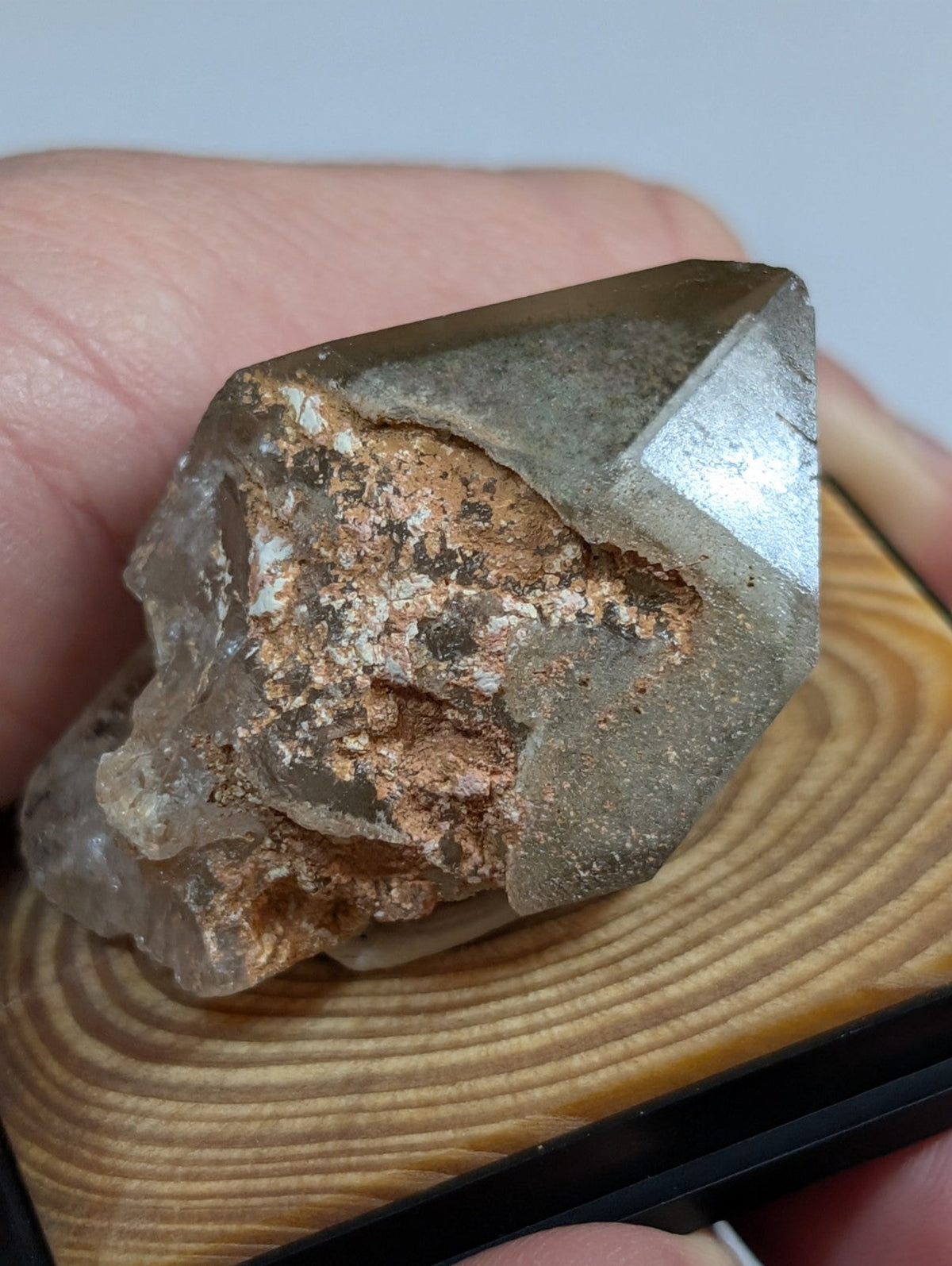 A translucent, faceted quartz crystal with a metallic sheen and internal coppery mineral inclusions.