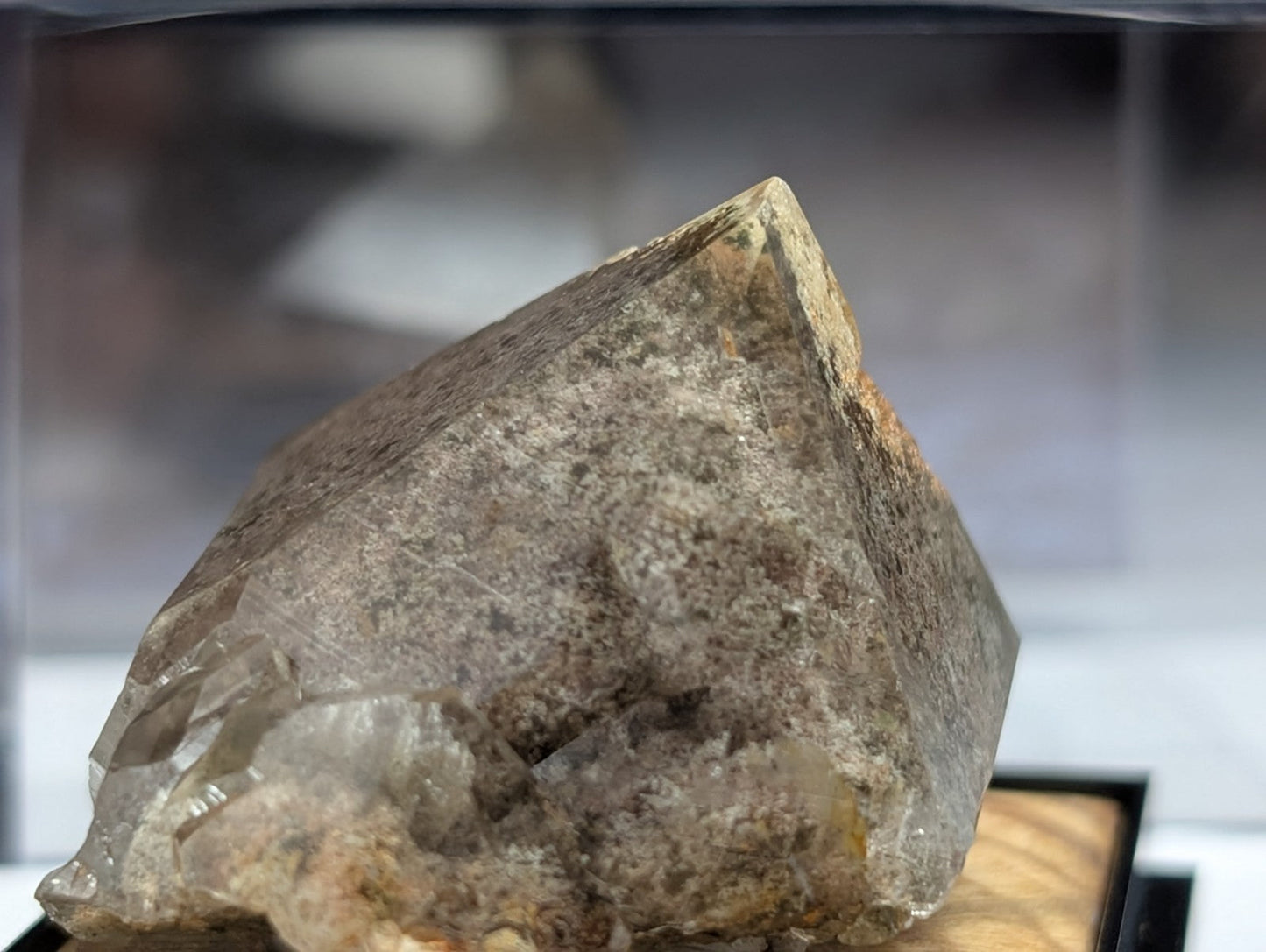 A translucent, grayish quartz crystal with a rough, faceted surface and subtle internal inclusions.