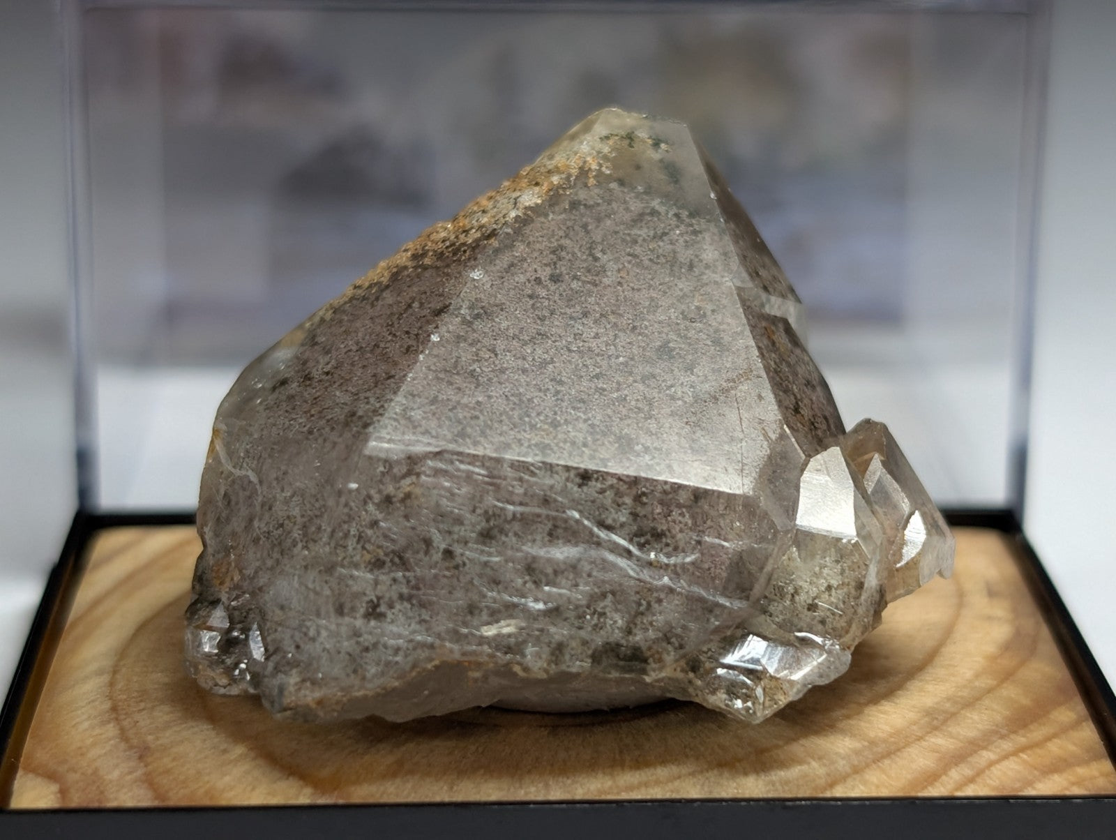A translucent, grayish-white quartz crystal with a rough, faceted surface and natural mineral inclusions.